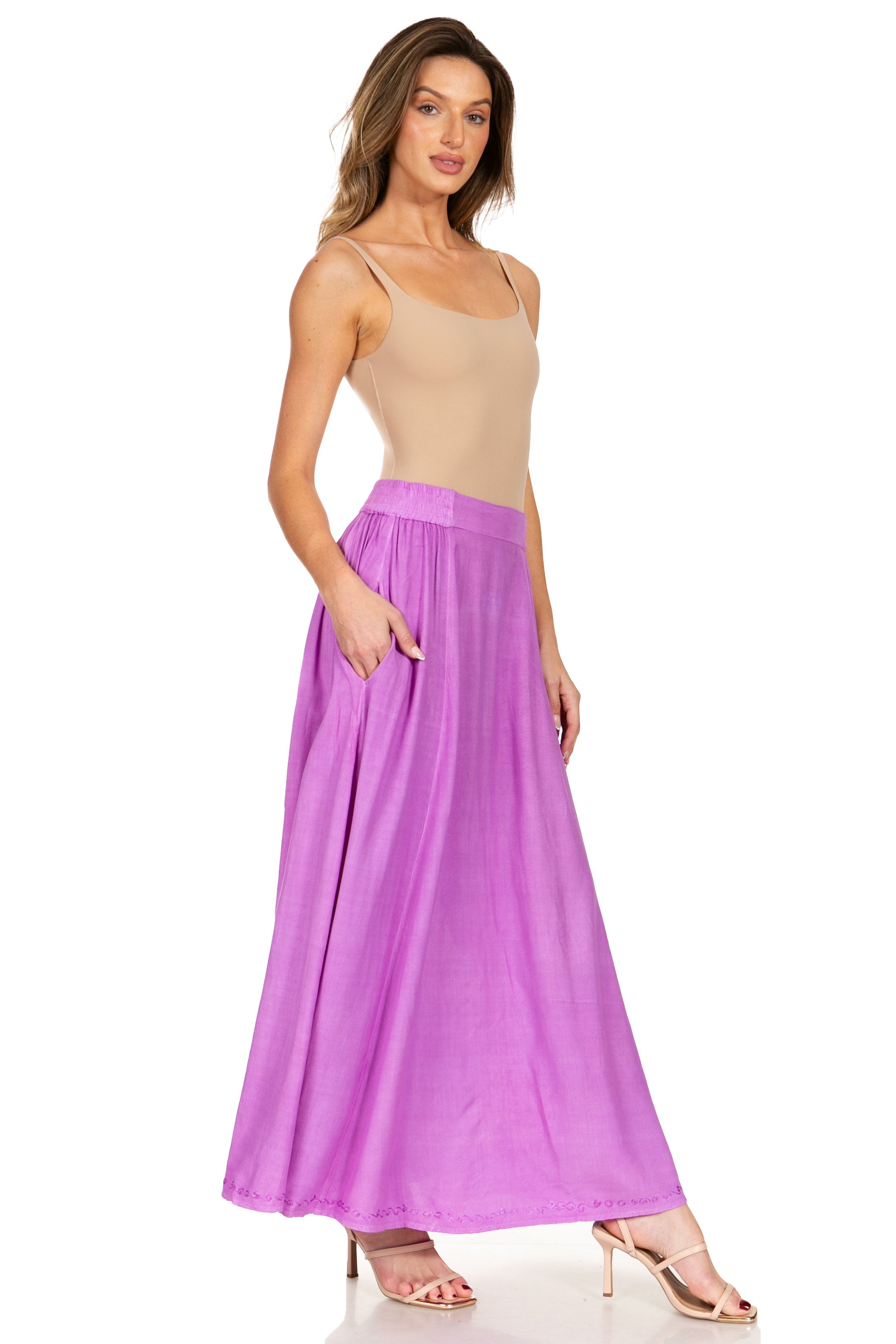 Woman wearing a beige top and purple skirt on a white background