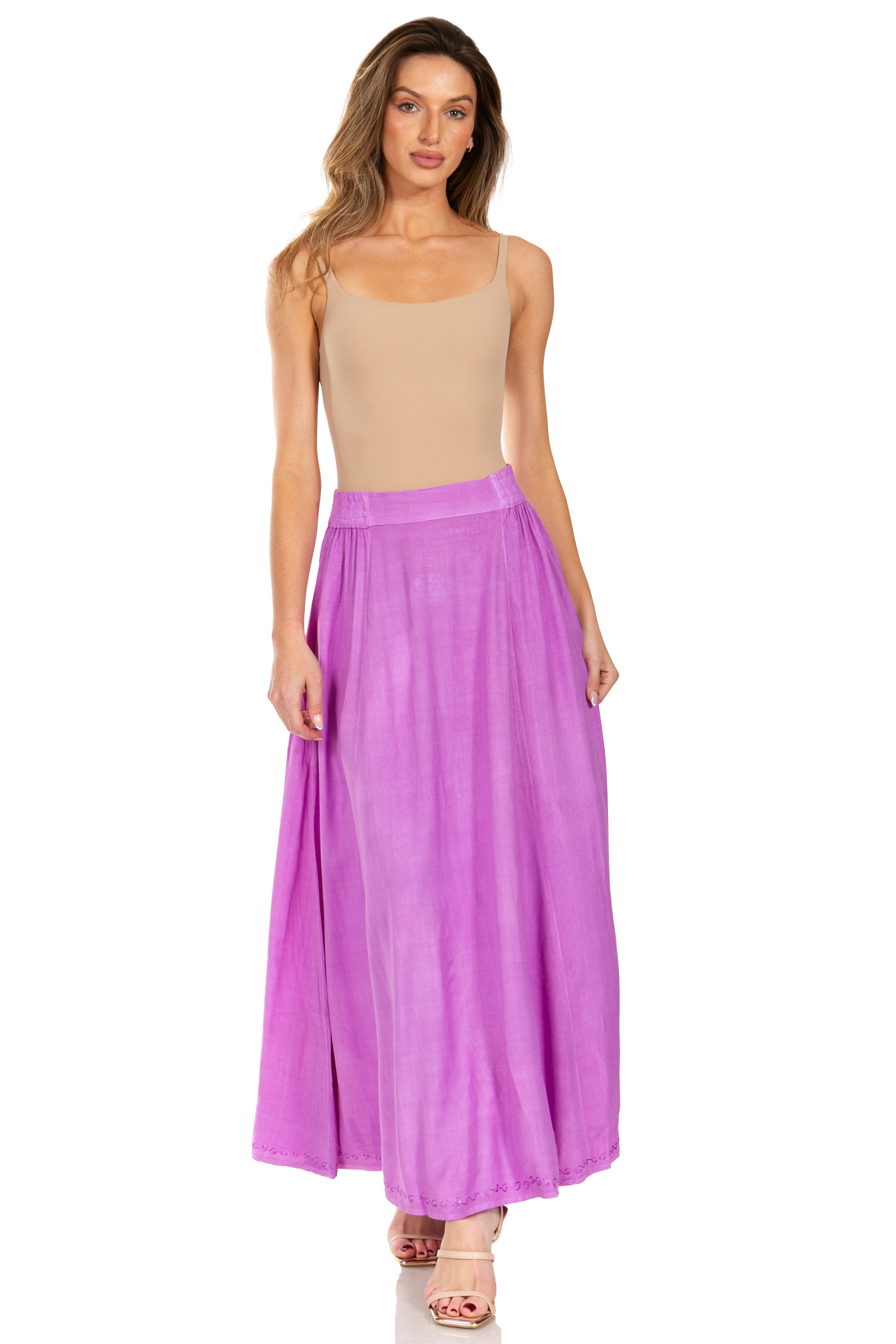 Woman wearing a beige top and purple skirt on a white background