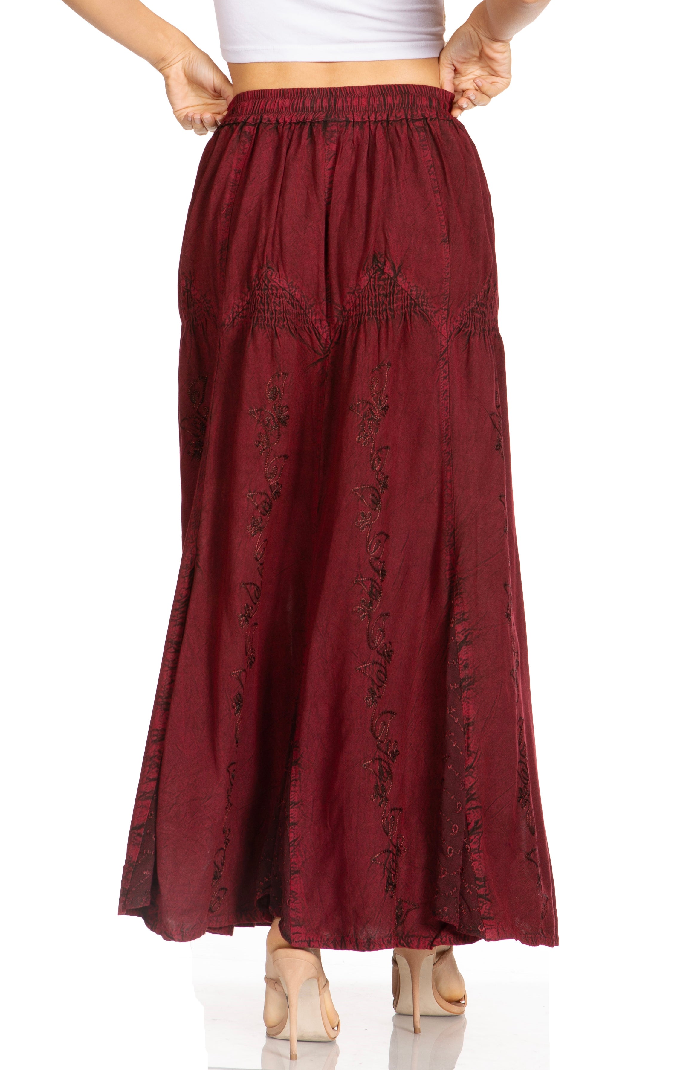 Maroon pants with floral embroidery worn by a person on a white background