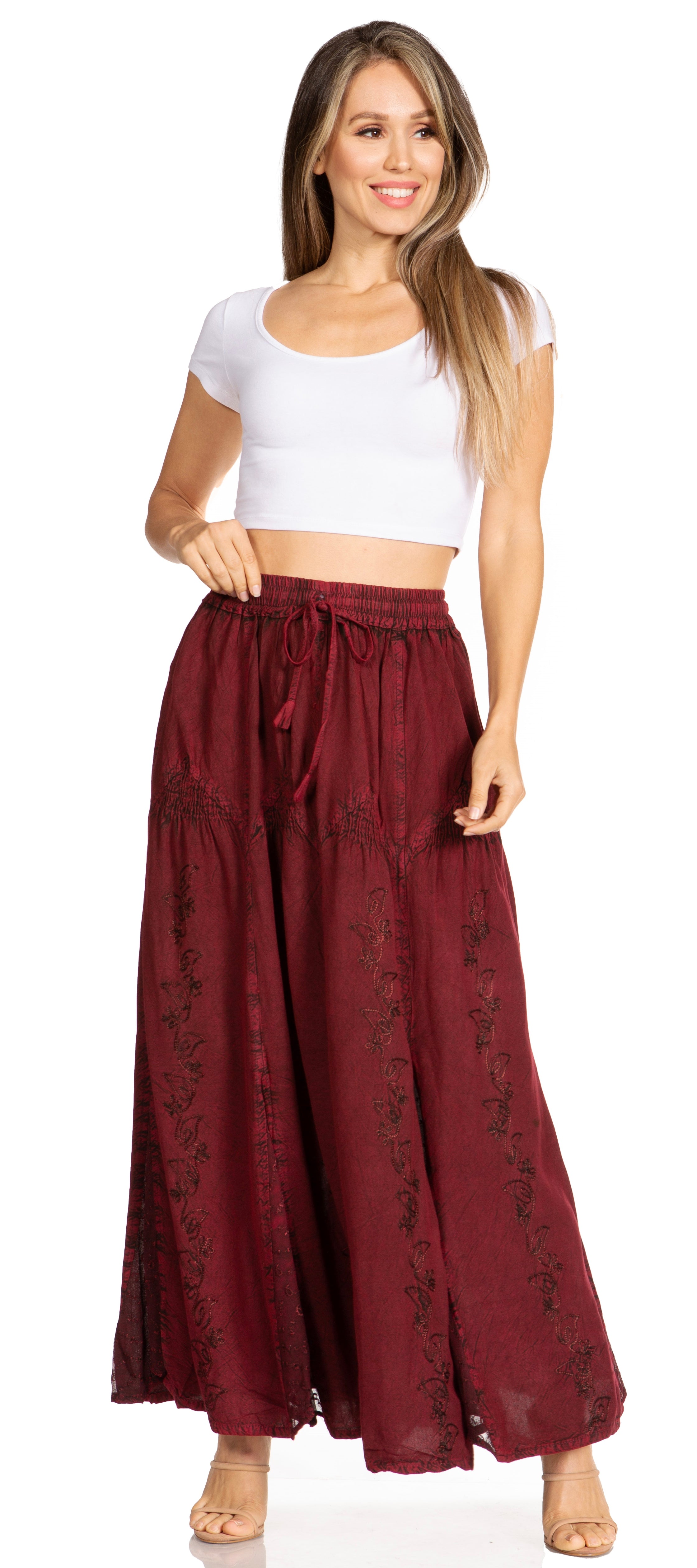 Woman wearing a white top and burgundy skirt with floral patterns on a white background