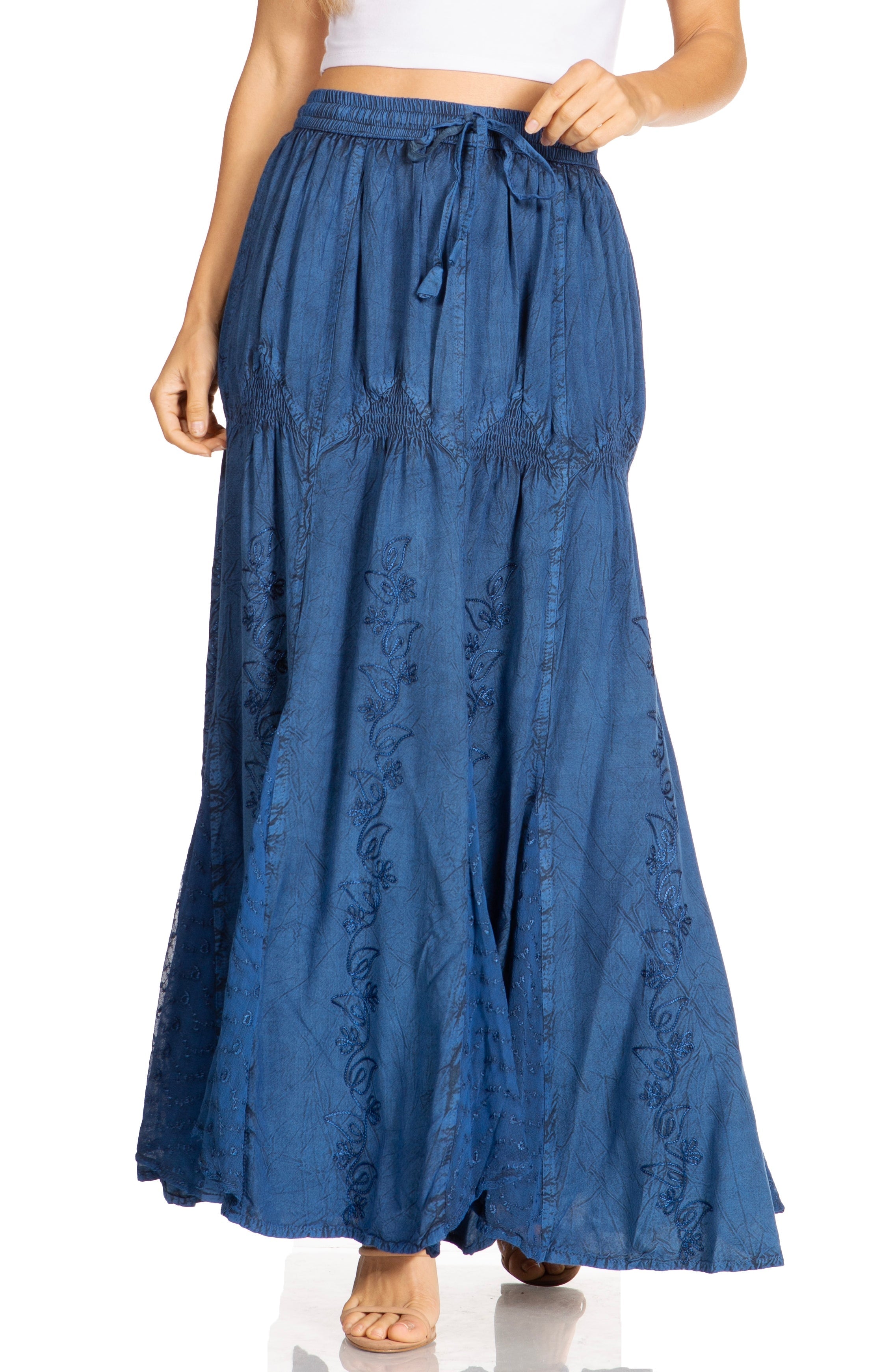 Blue denim skirt with floral embroidery worn by a person on a white background