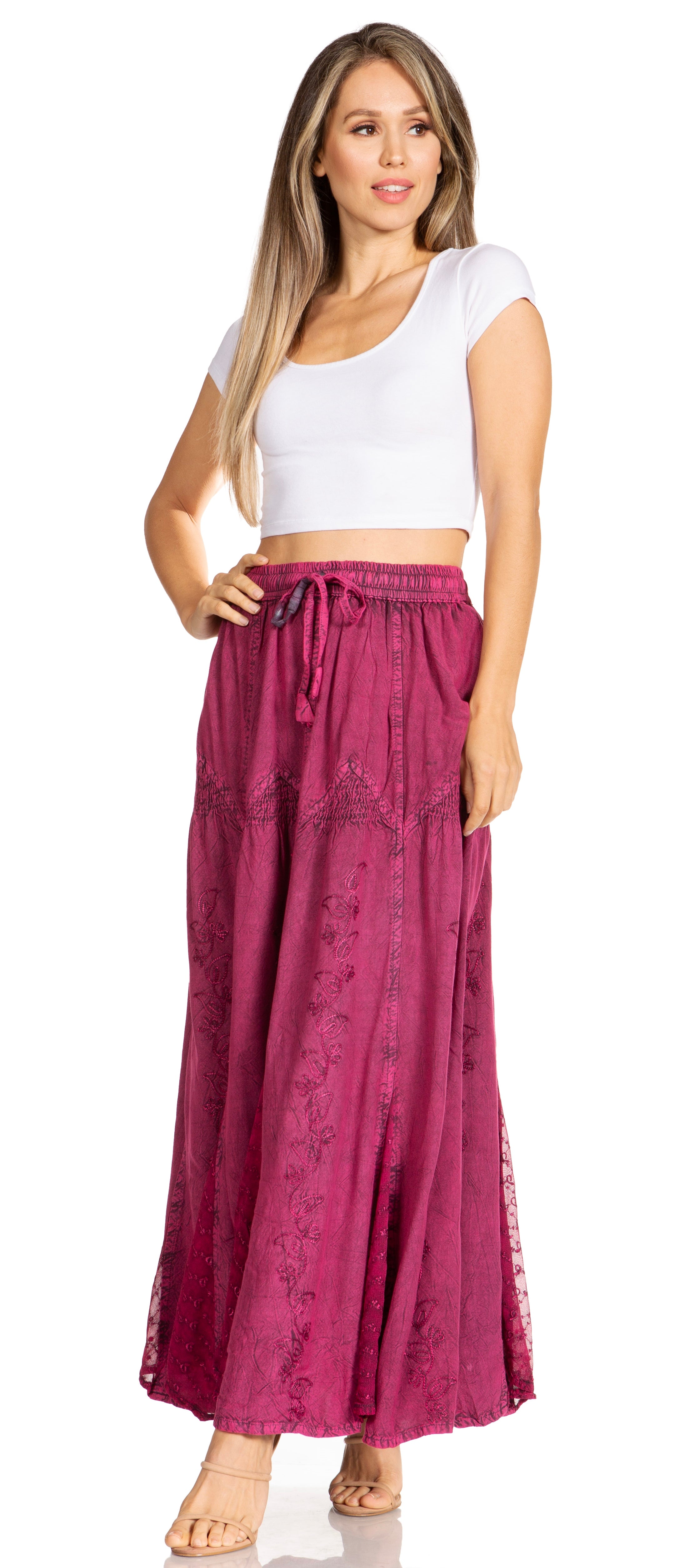 Woman wearing a white top and magenta pants on a white background