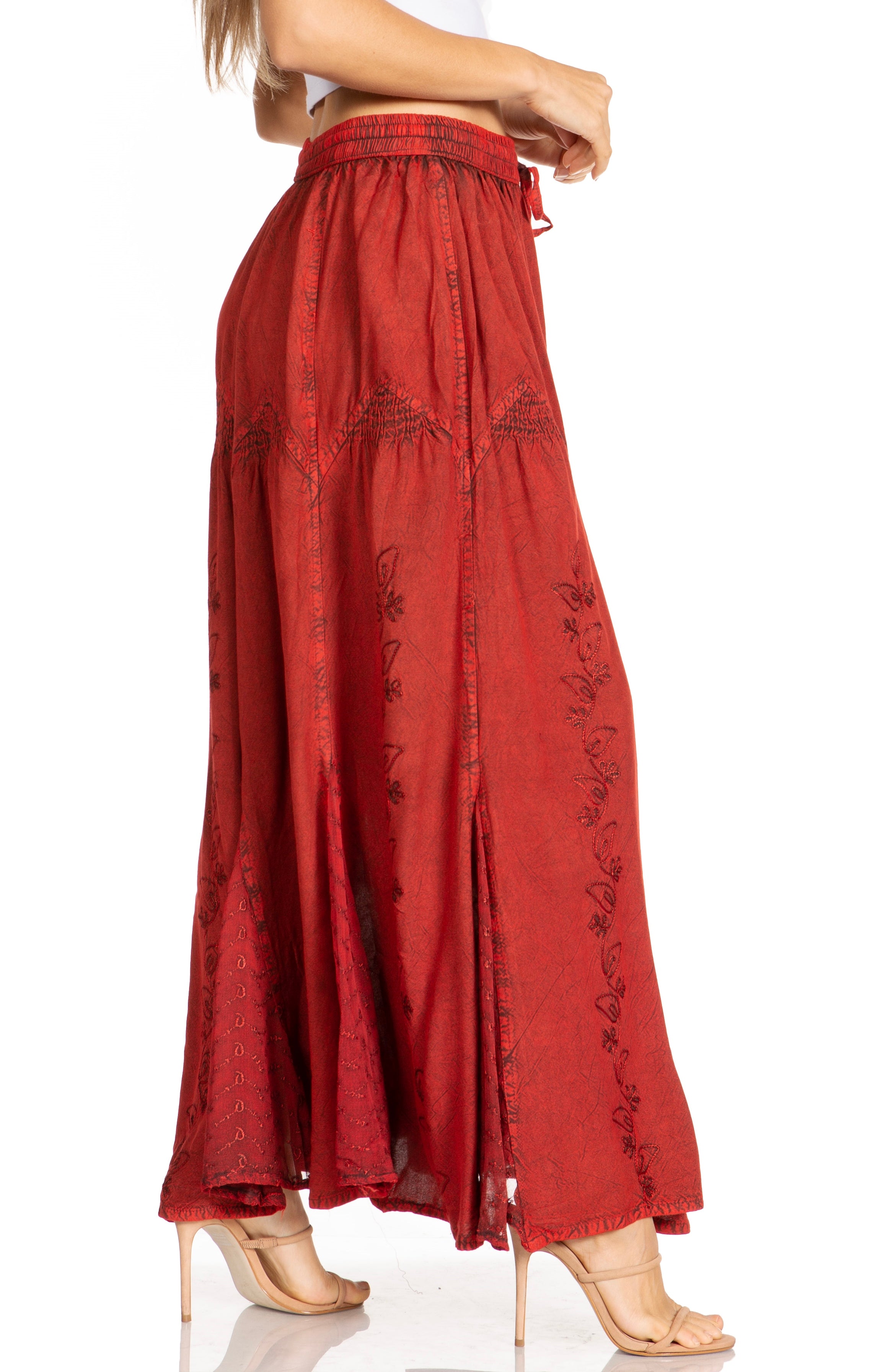 Red embroidered skirt worn by a person on a white background