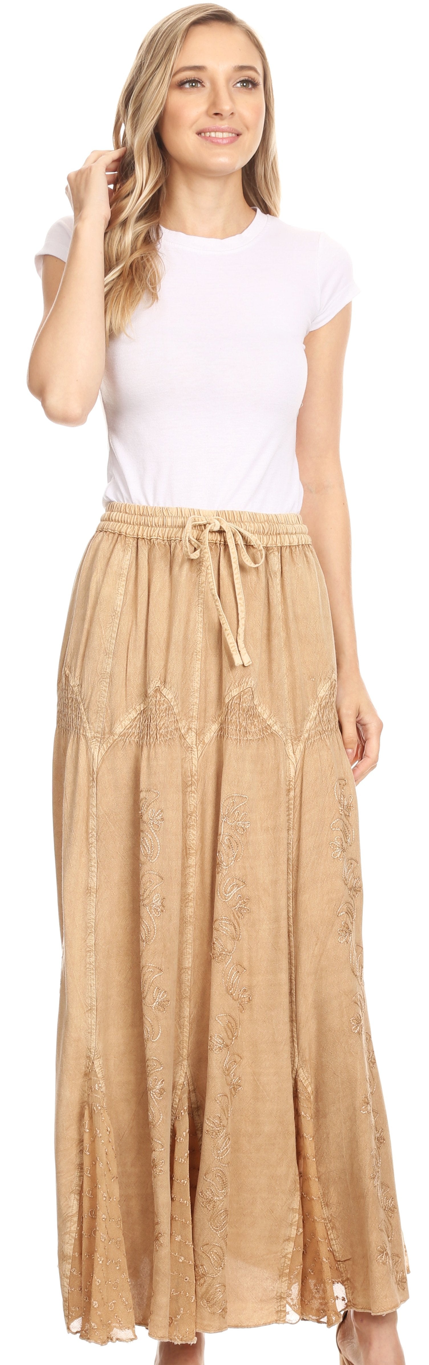 Woman wearing a white top and beige skirt with a plain background