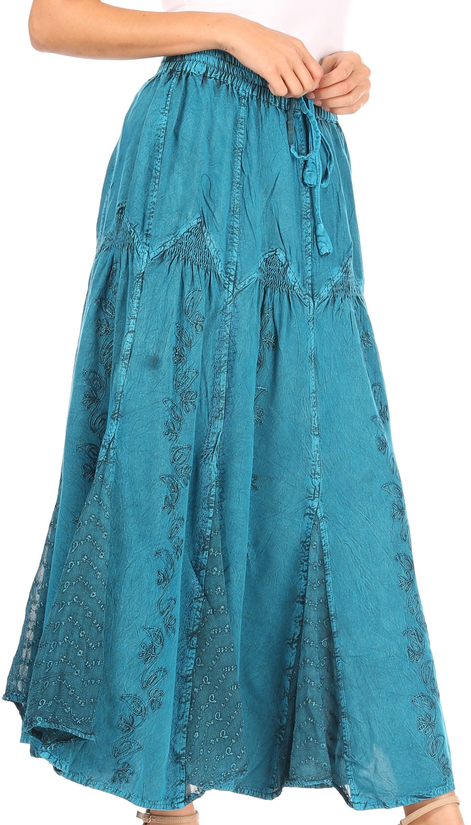 Teal skirt with floral pattern worn by a person on a white background
