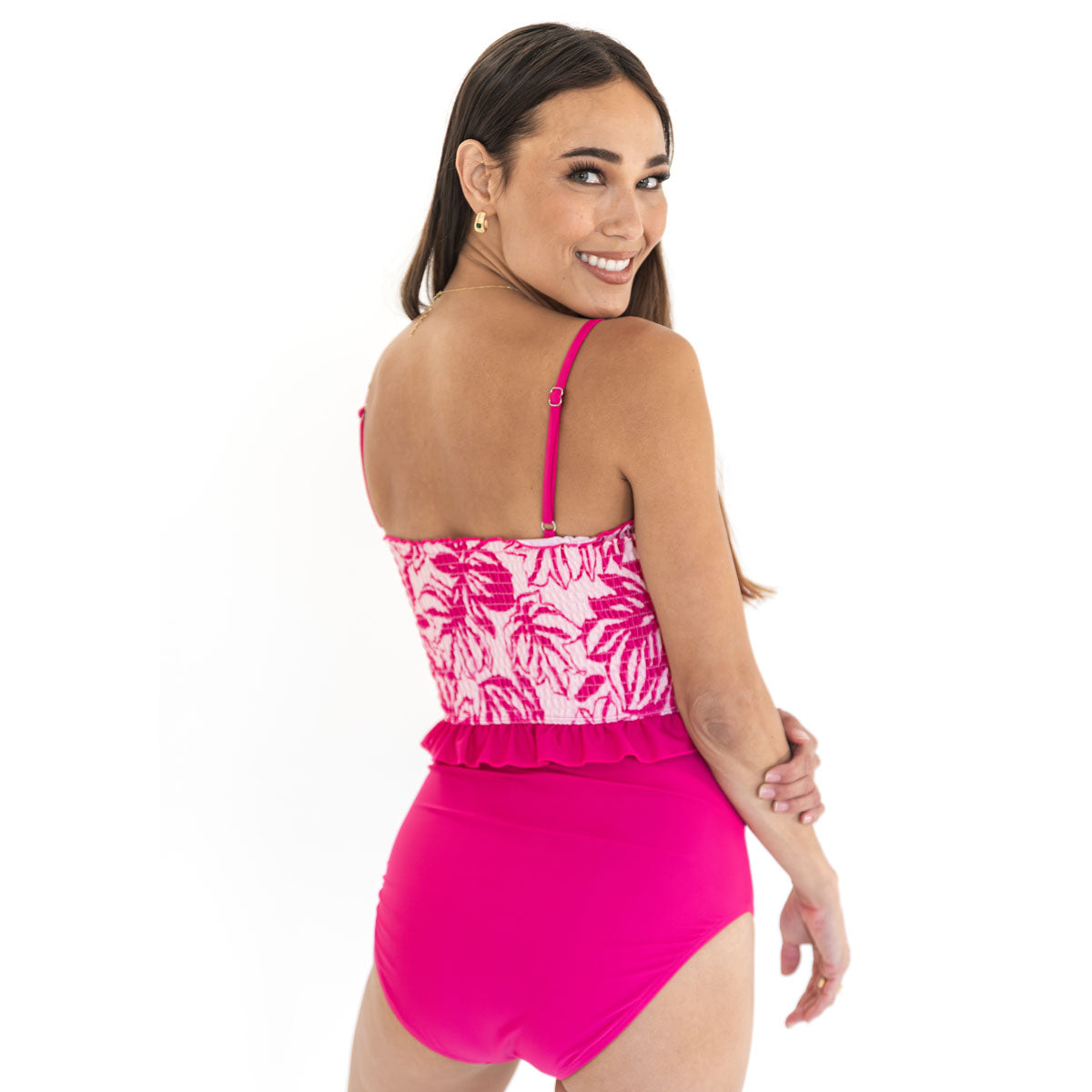 Woman wearing a pink swimsuit with a white floral pattern on a white background