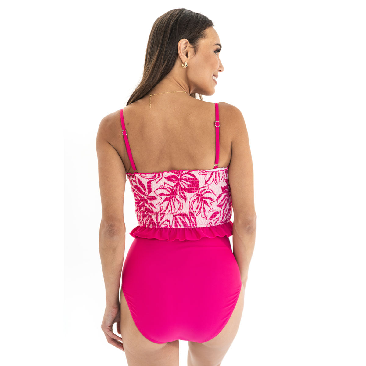 Woman wearing a pink and white floral swimsuit on a white background