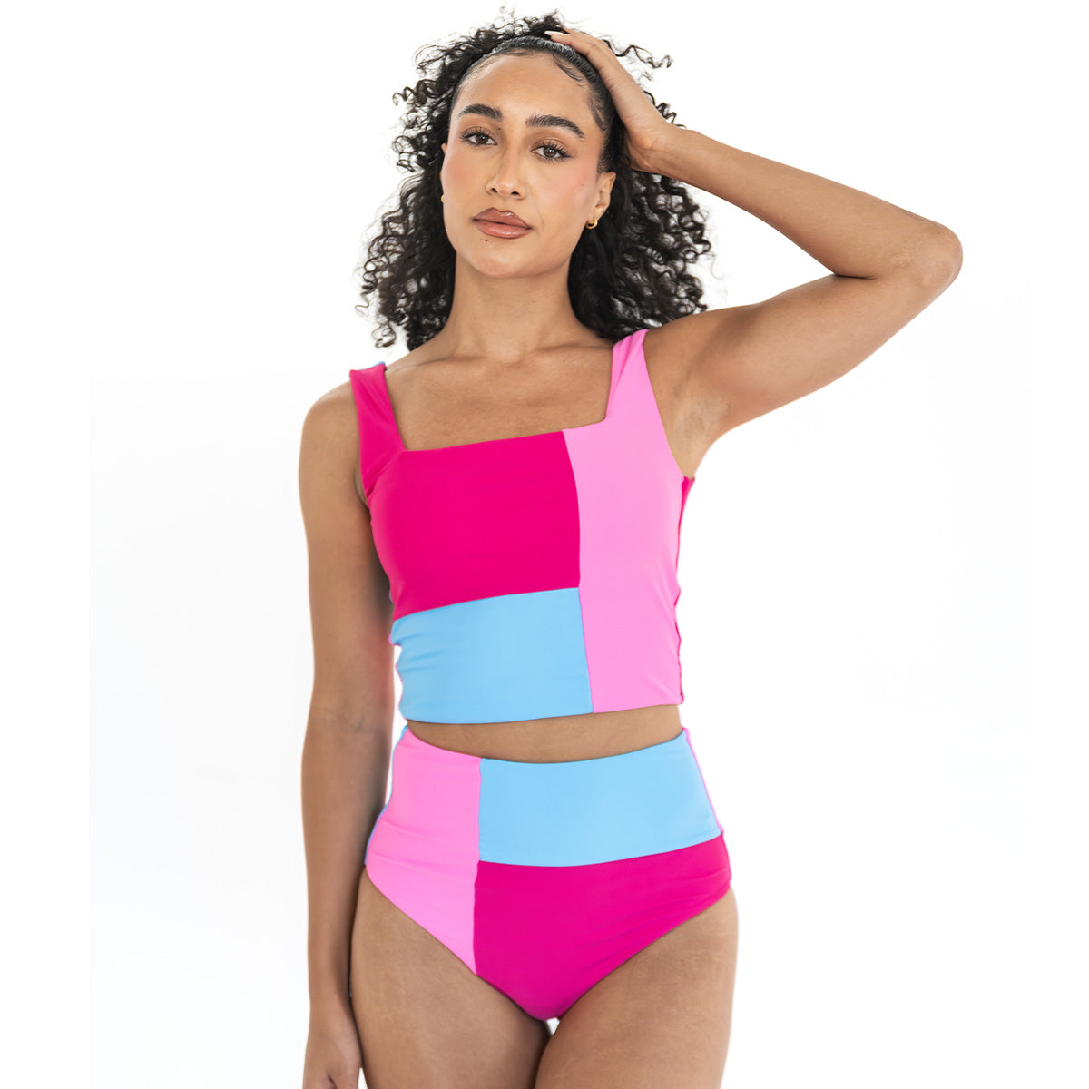 Woman wearing a colorful patchwork swimsuit on a white background