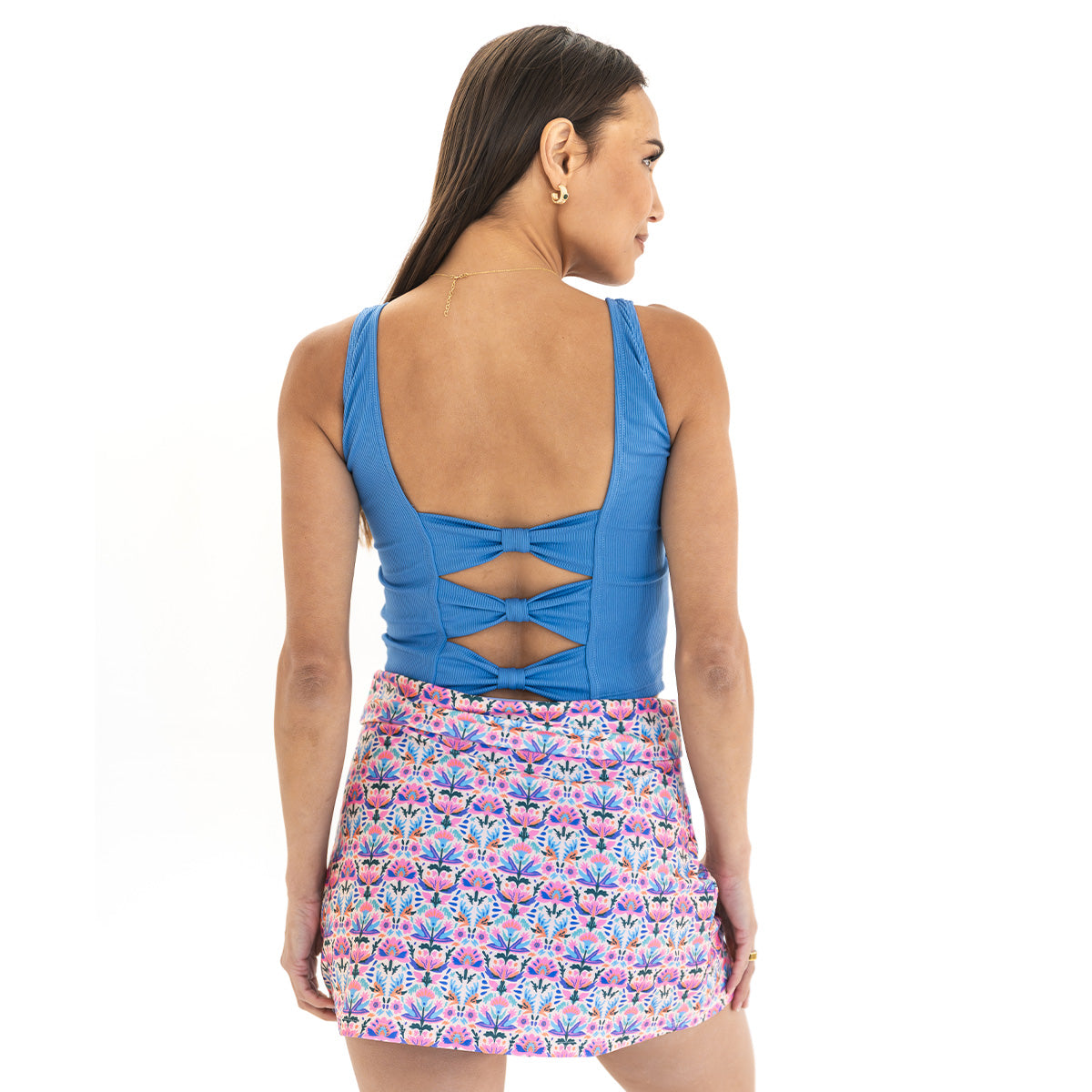Woman wearing a blue top and floral skirt on a white background