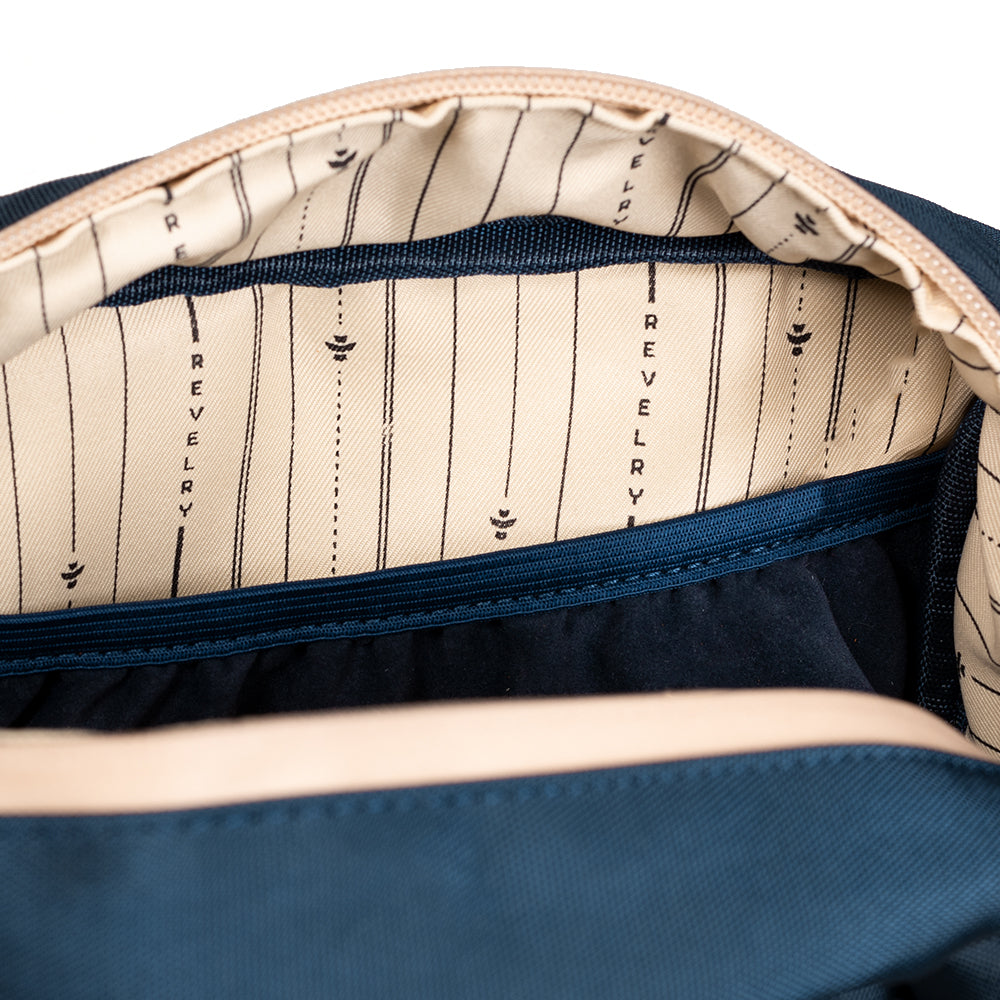 Navy blue bag interior with beige lining featuring 'Revelry' branding.