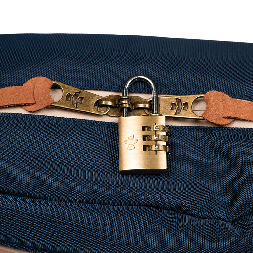 Brass padlock on a navy blue bag with leather strap