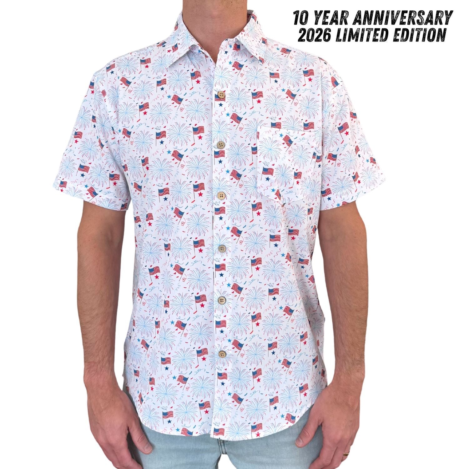 Short-sleeve shirt with a pattern of small flags on a white background, labeled '10 Year Anniversary 2026 Limited Edition'.