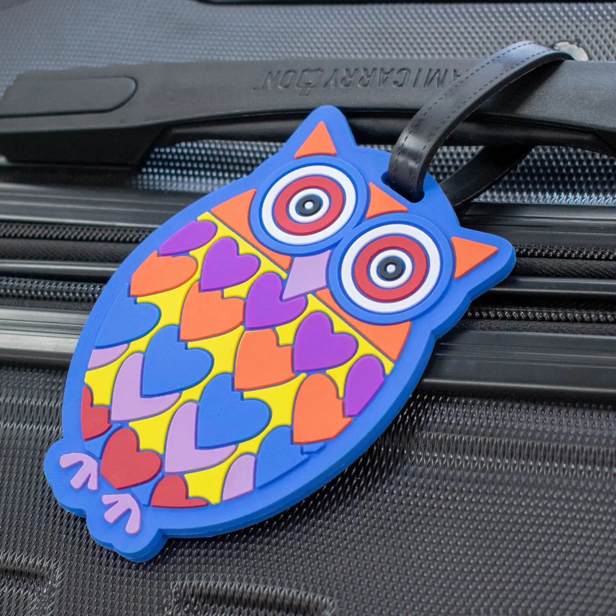 Colorful owl-shaped luggage tag on a suitcase