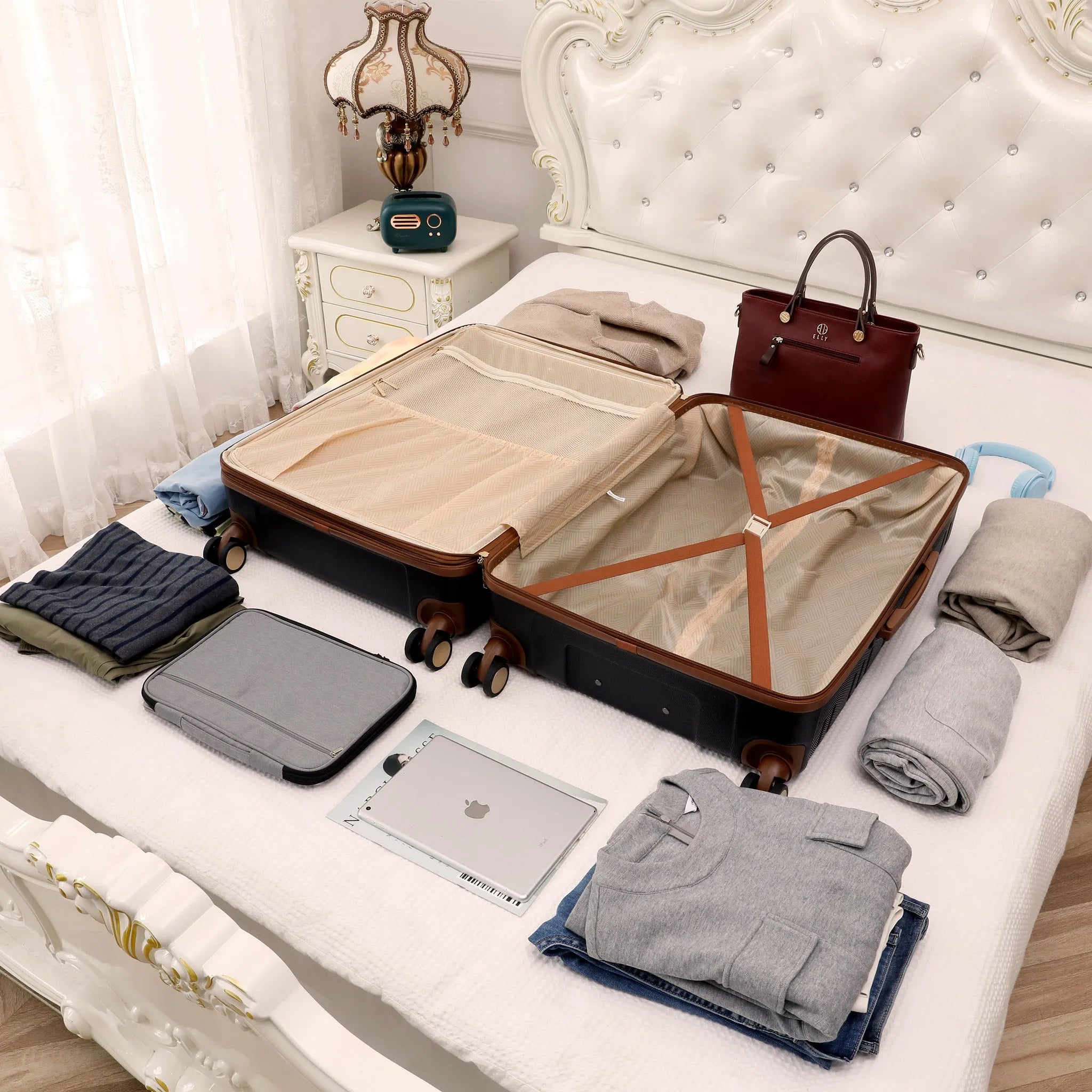 Open suitcase on a bed with clothes and a laptop, in a bedroom setting.