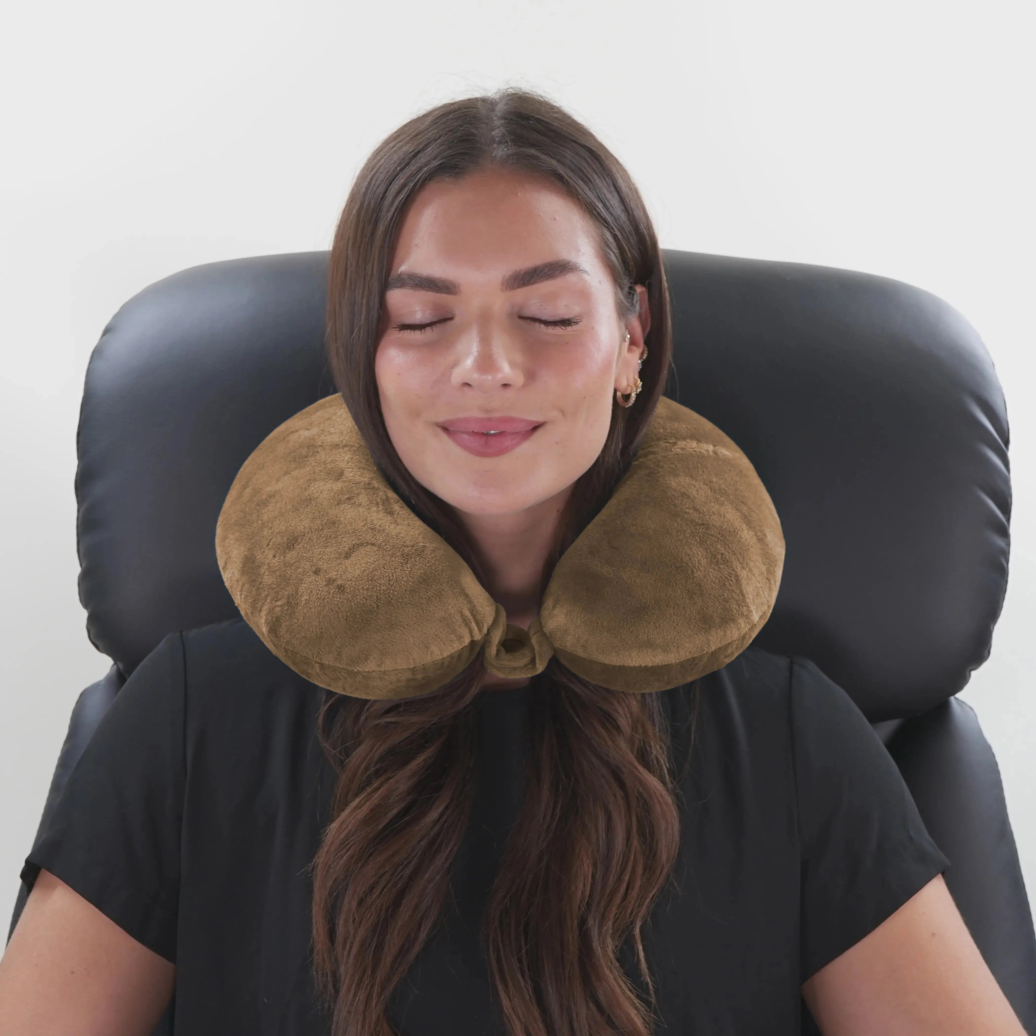 Woman using a brown neck pillow in a chair