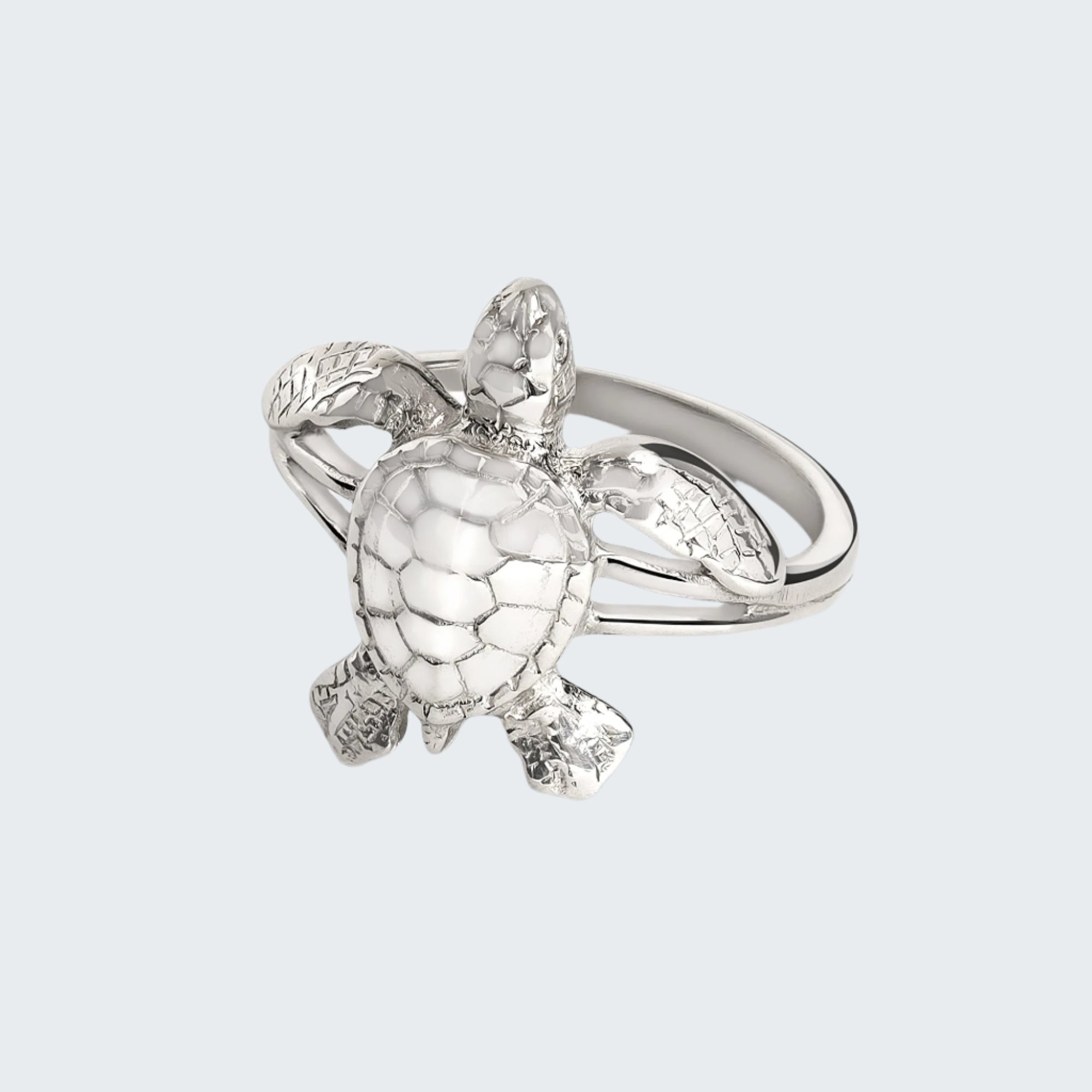 Silver turtle-shaped ring on a light gray background
