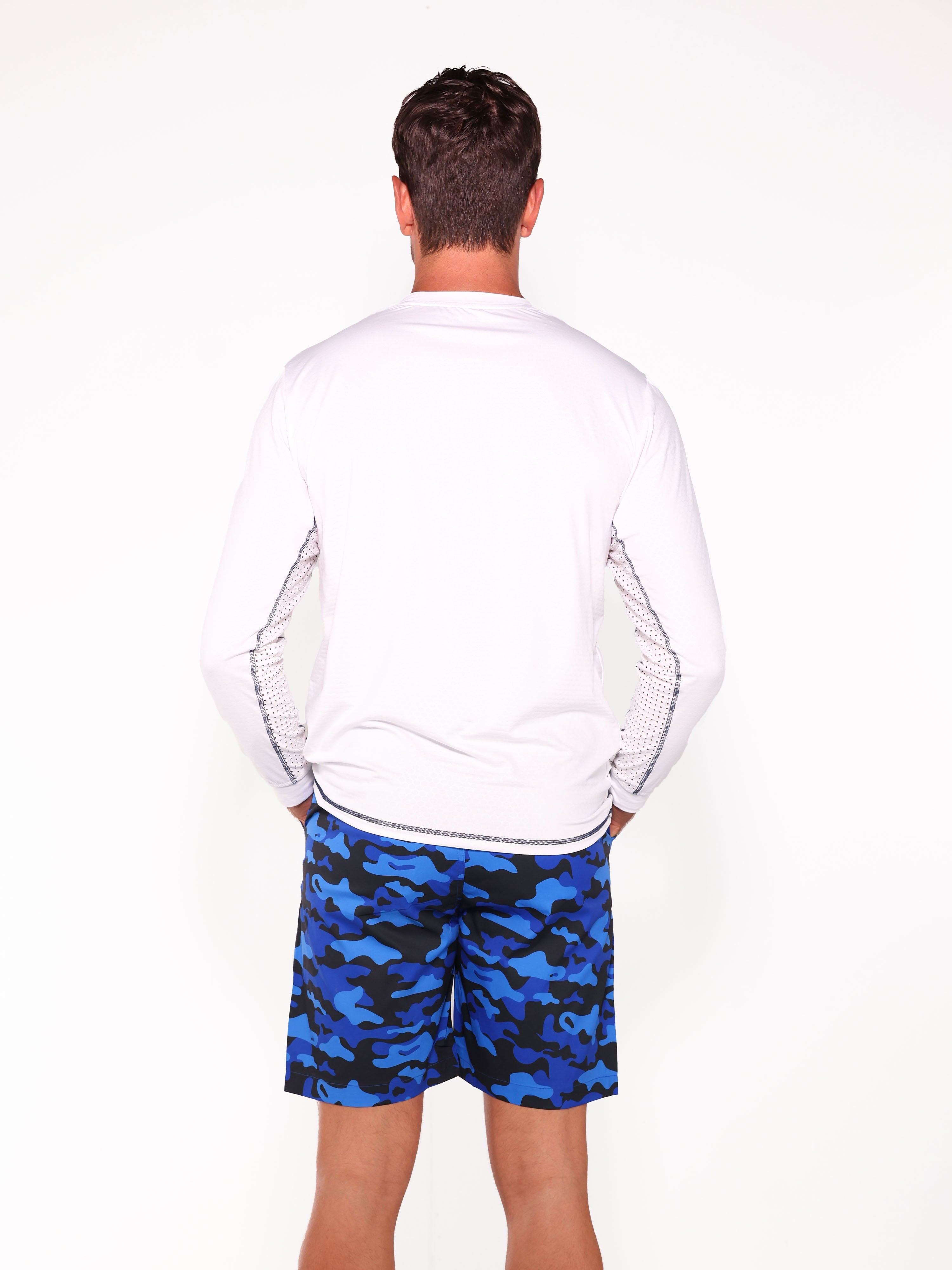 Person wearing a white sweatshirt and blue camouflage shorts on a white background