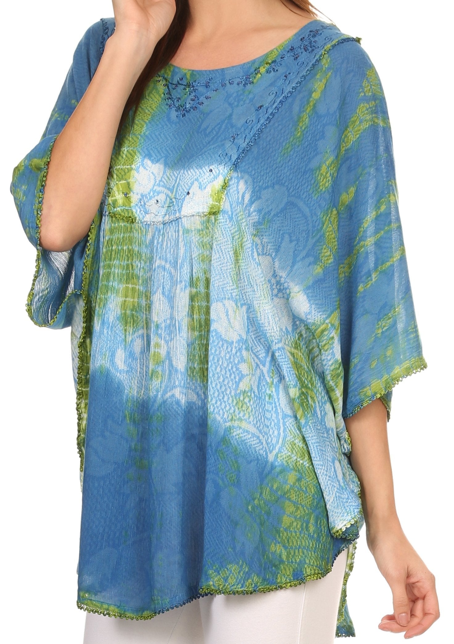 Blue and green patterned top worn by a person on a white background