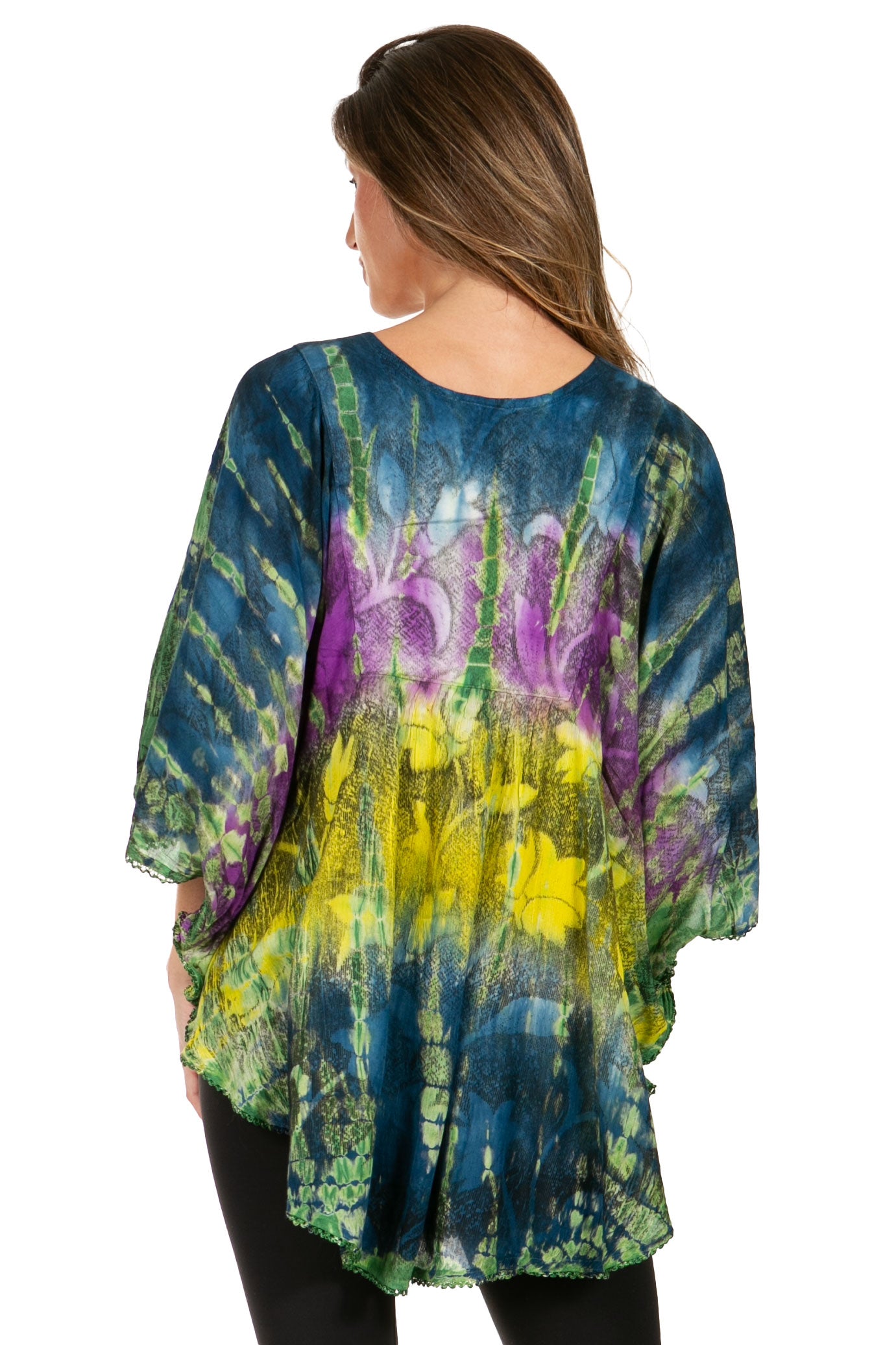 Woman wearing a tie-dye shirt with blue, green, and purple patterns on a white background