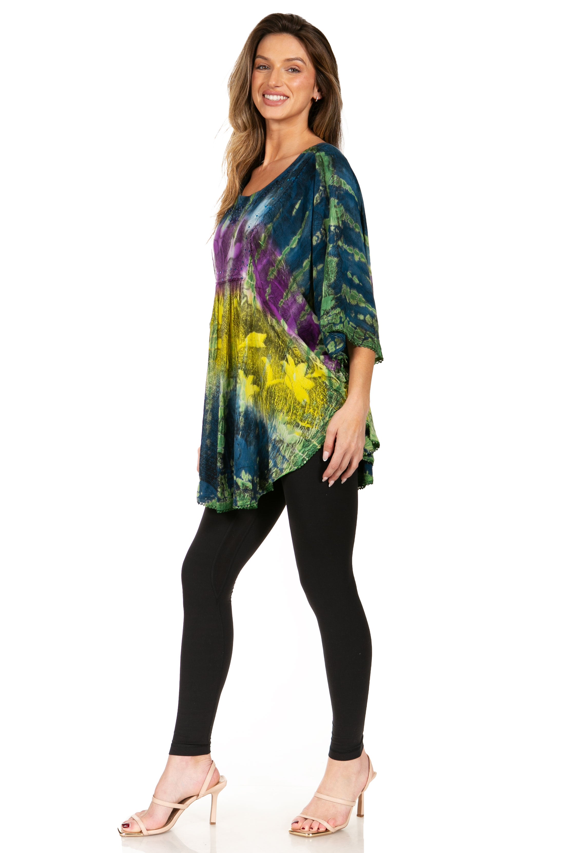 Woman wearing a colorful tie-dye top and black leggings on a white background
