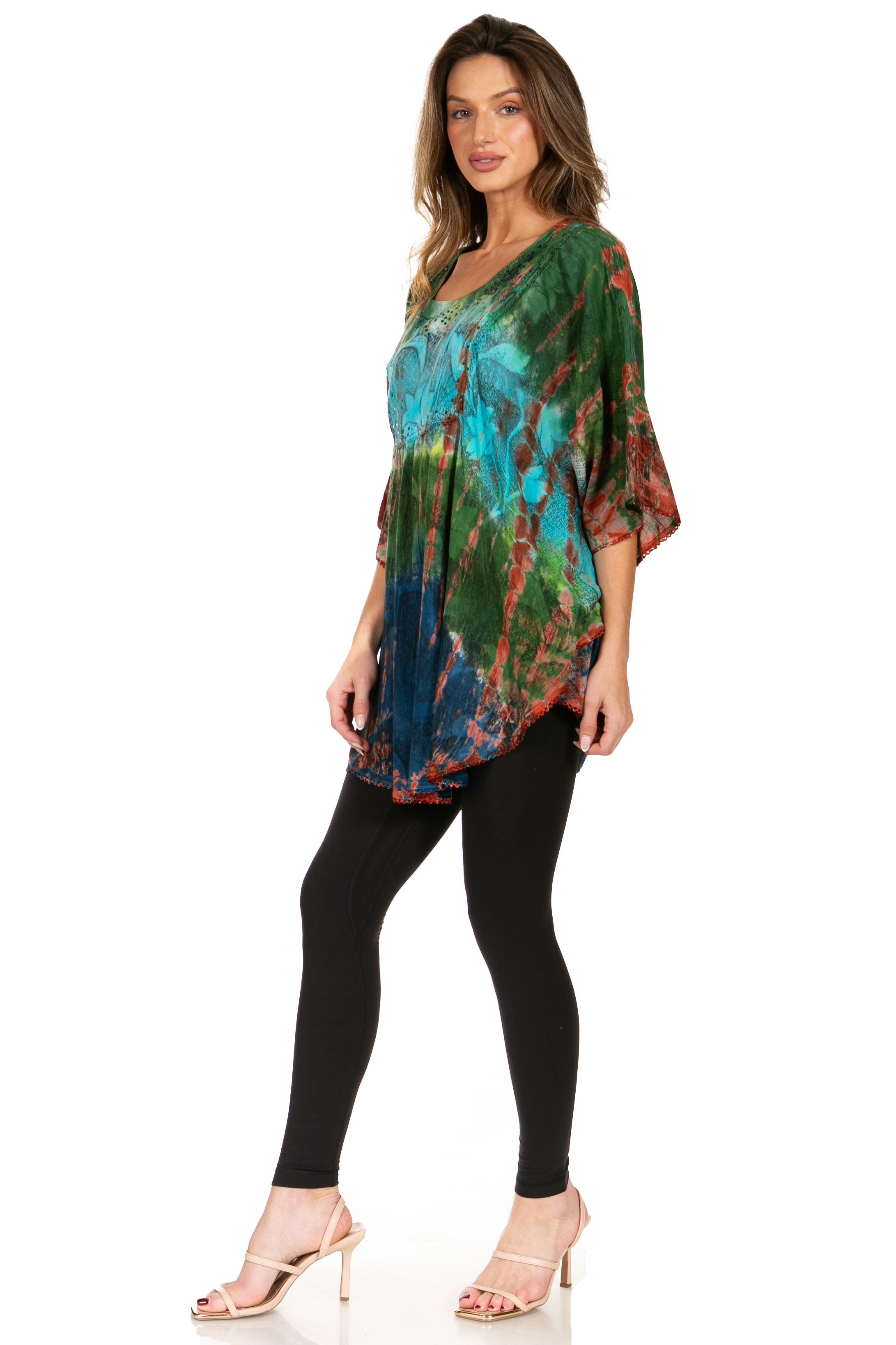 Woman wearing a colorful tie-dye top and black leggings on a white background