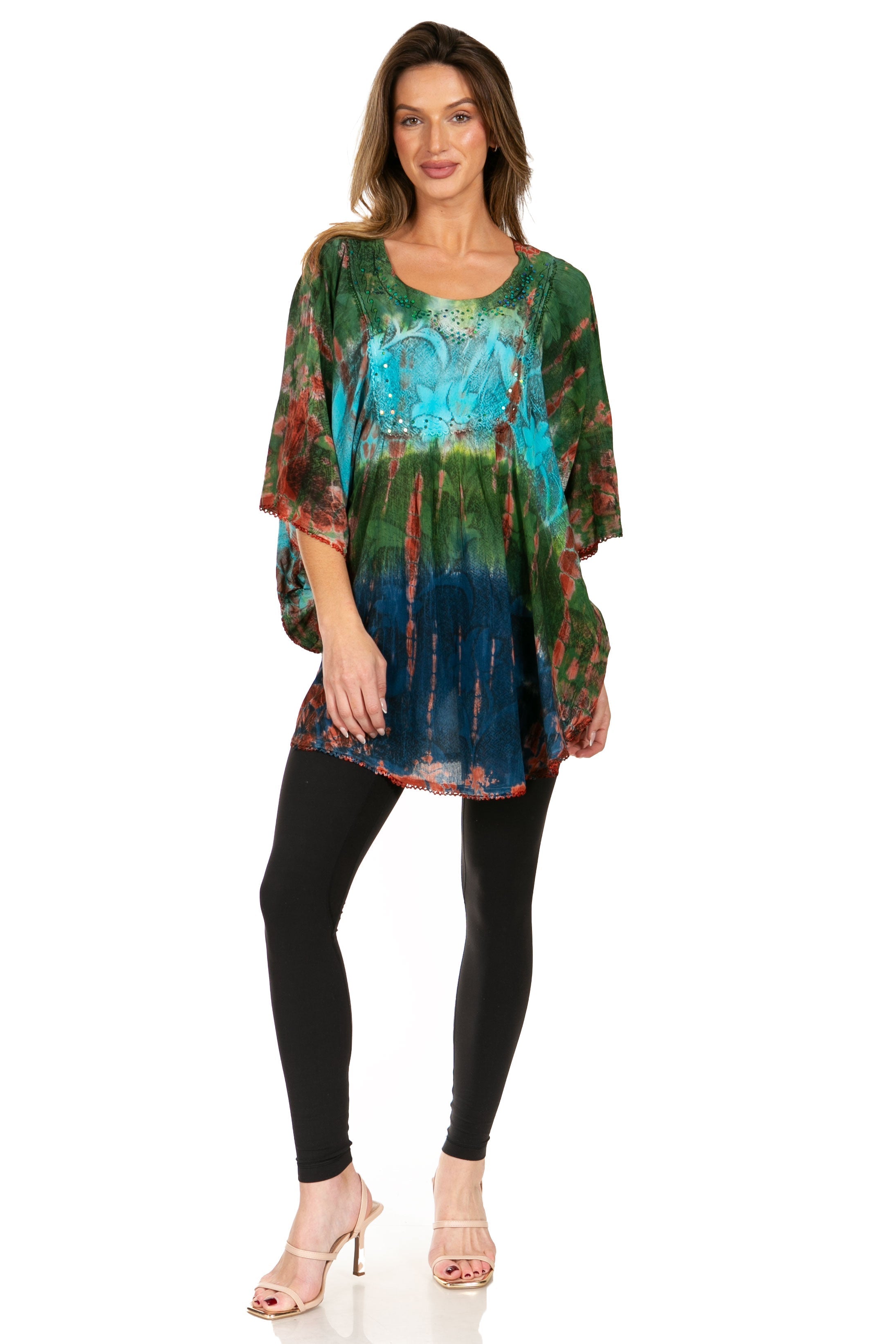 Woman wearing a colorful tie-dye top and black leggings on a white background