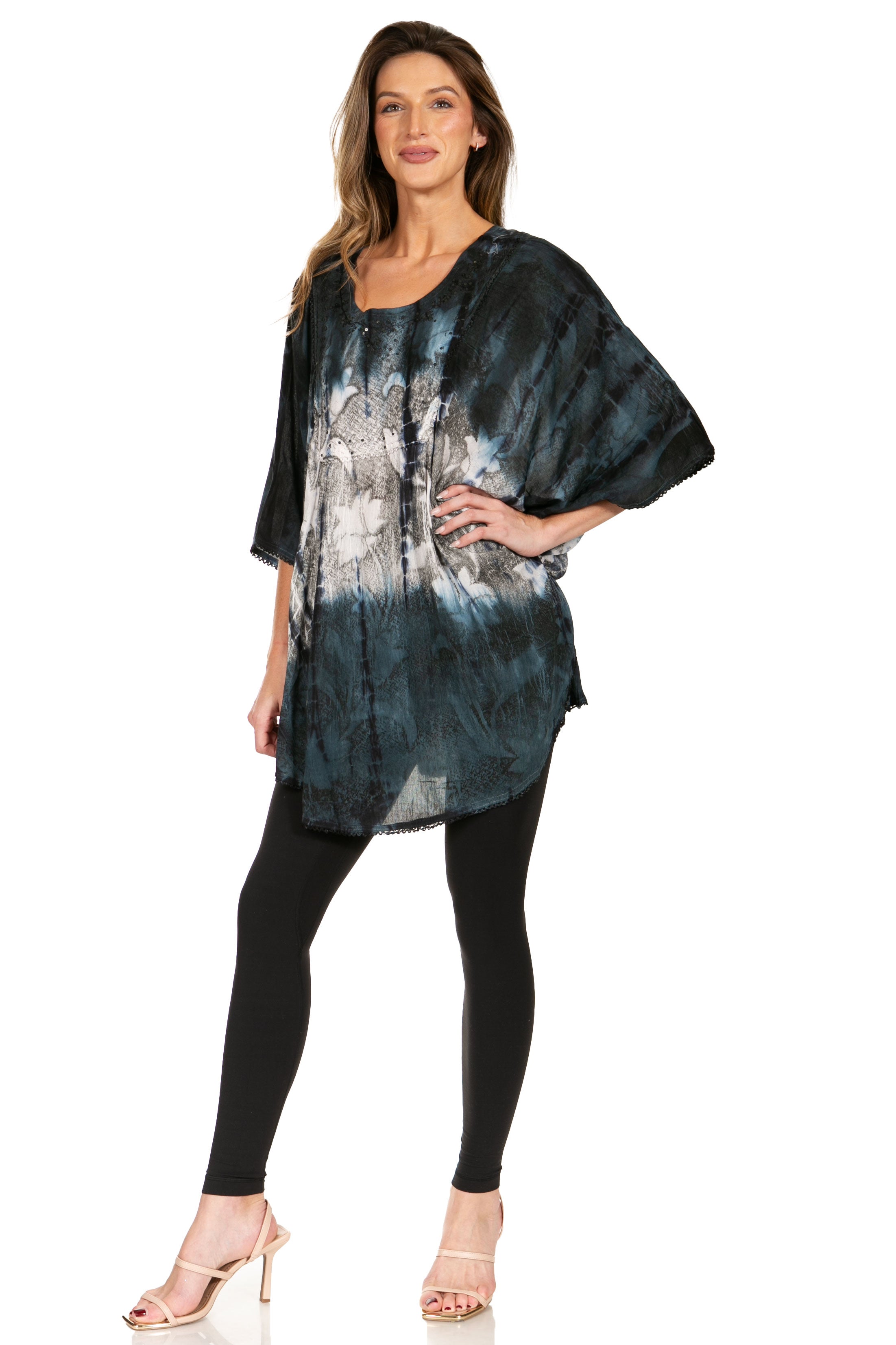 Woman wearing a tie-dye shirt and black leggings on a white background