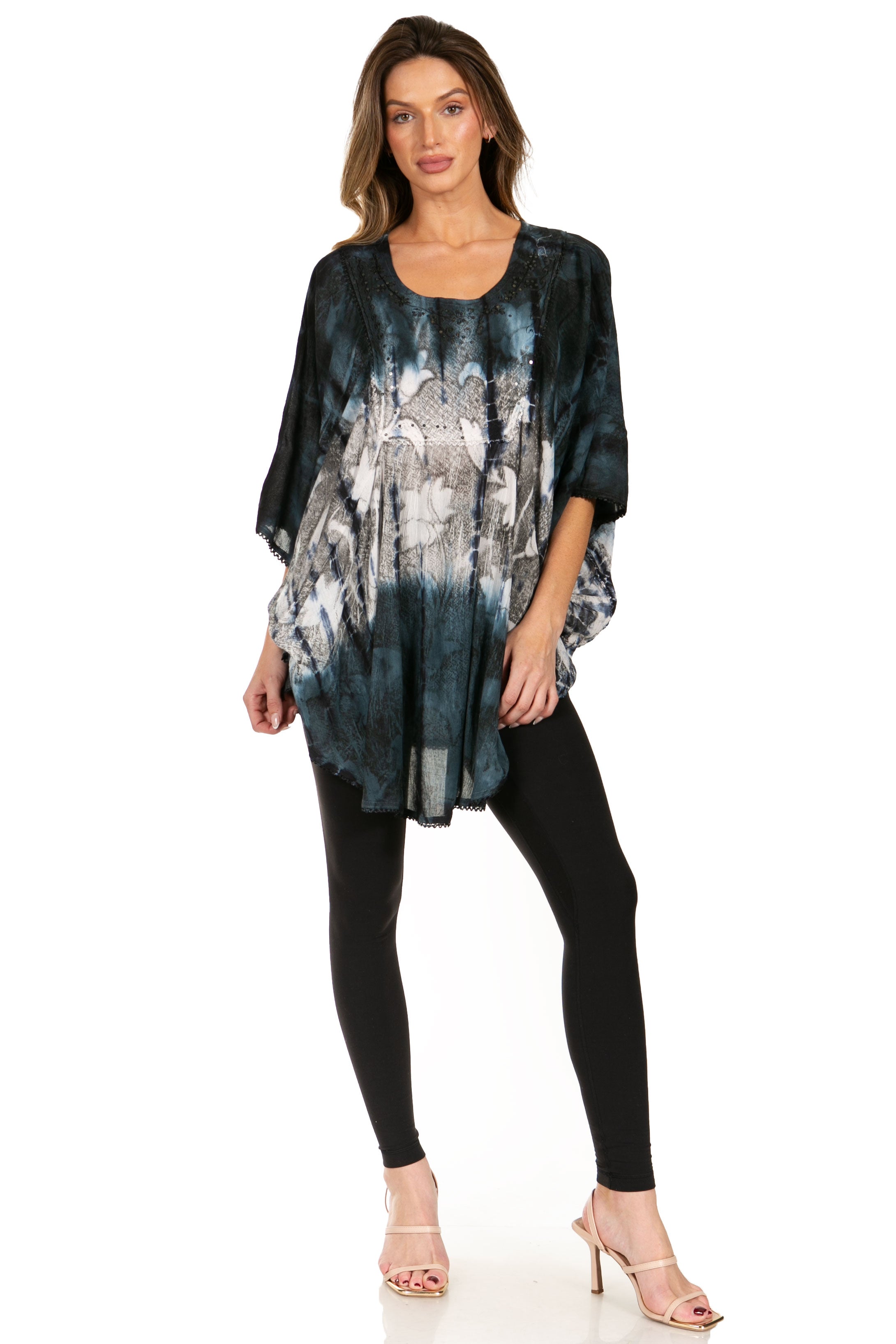 Woman wearing a black and gray patterned top with black leggings on a white background