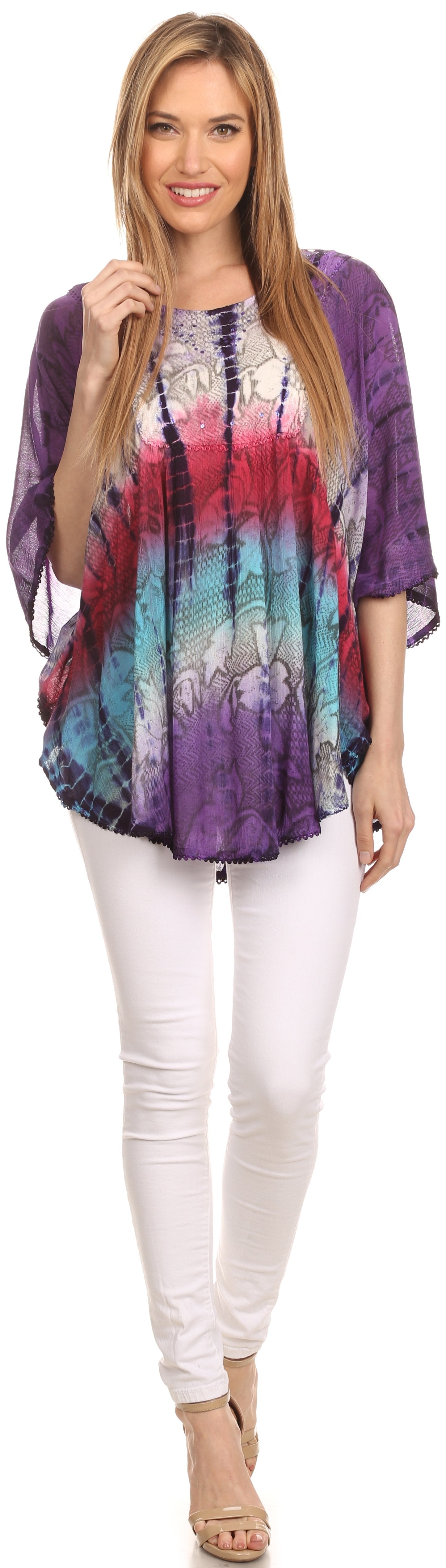Woman wearing a tie-dye shirt and white pants on a white background