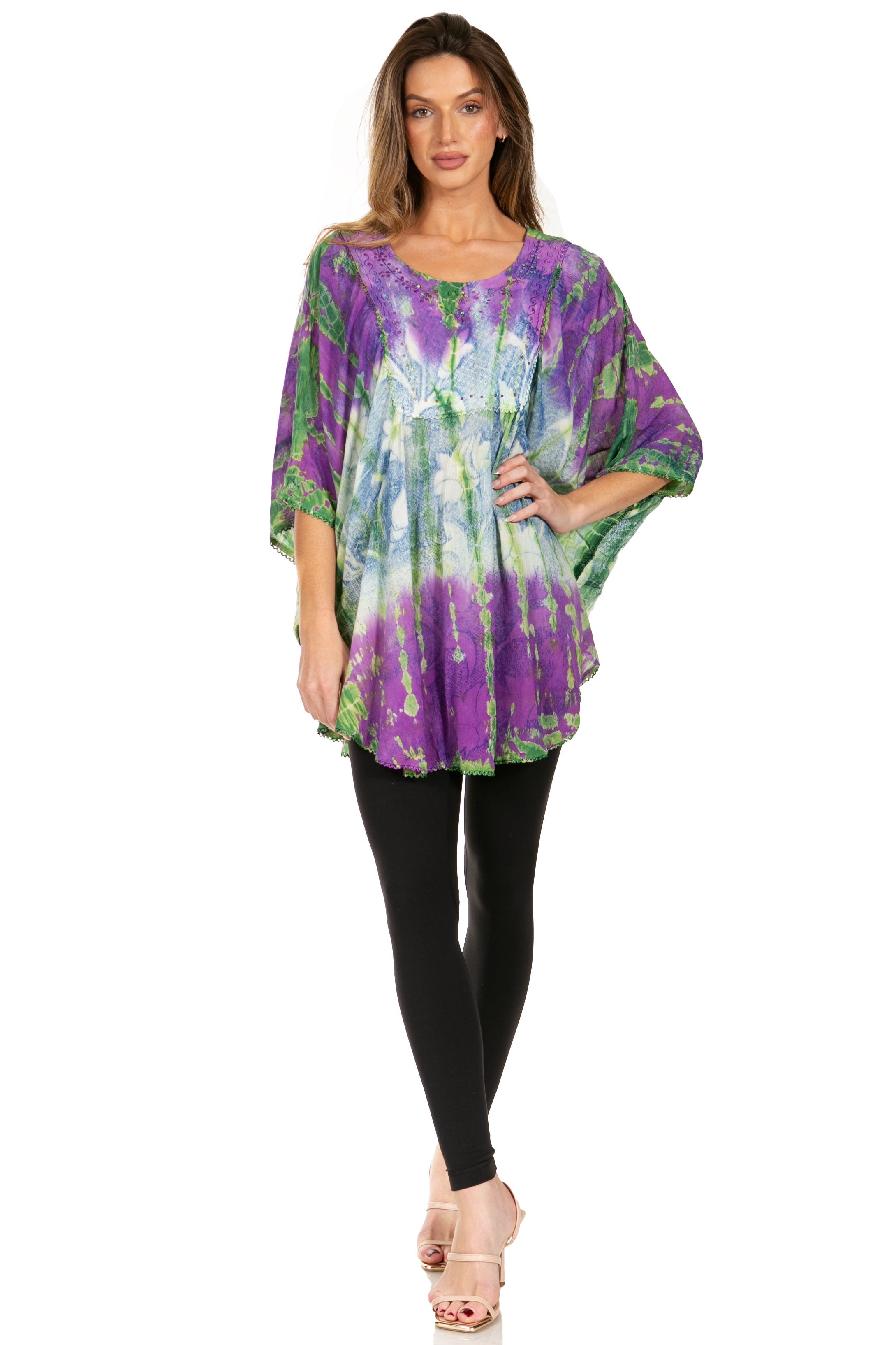 Woman wearing a colorful tie-dye top and black leggings on a white background