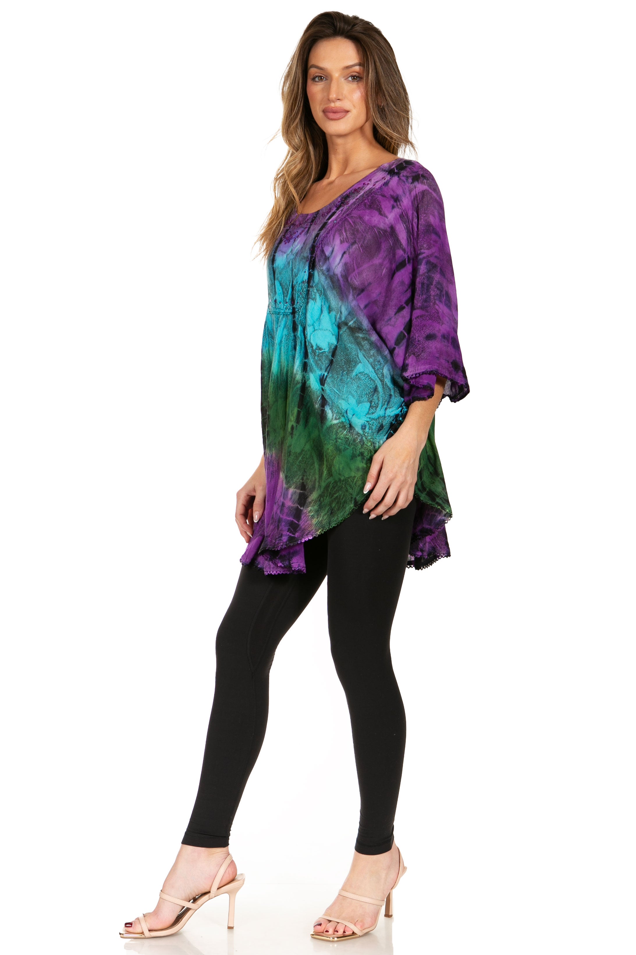 Woman wearing a tie-dye top and black leggings on a white background