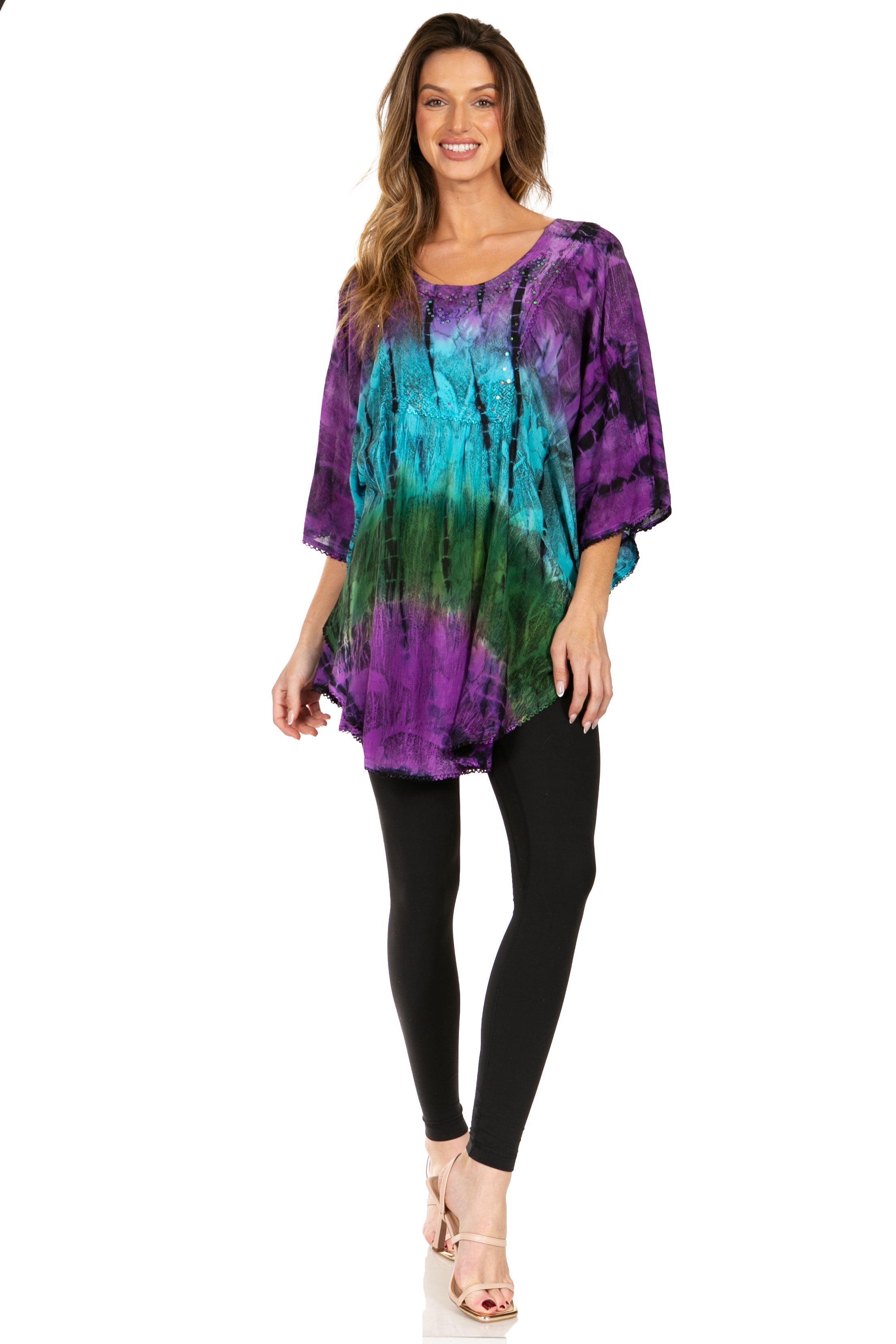 Woman wearing a tie-dye shirt and black leggings on a white background