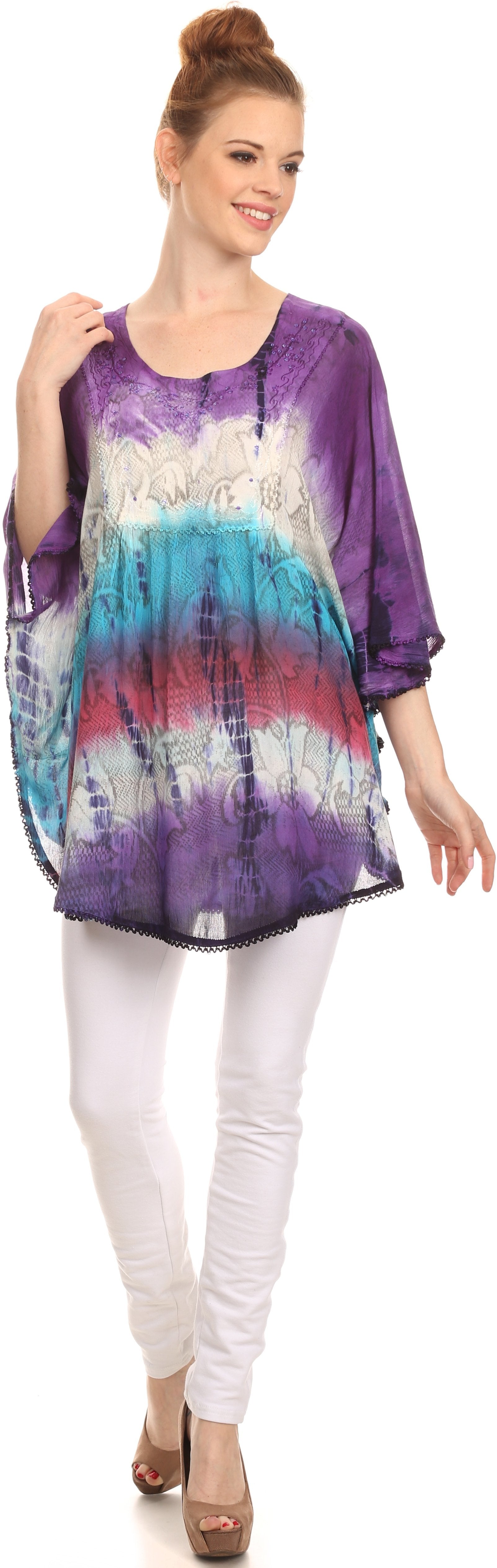 Woman wearing a tie-dye shirt and white pants on a white background