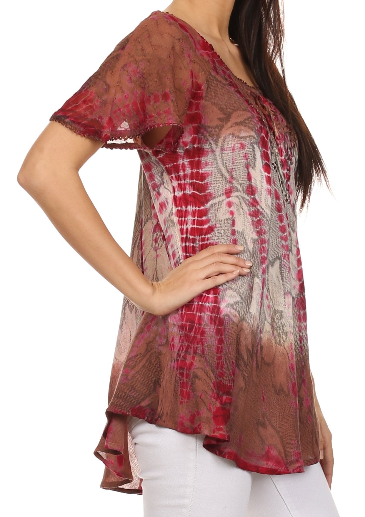 Woman wearing a patterned sheer top with red and brown tones on a white background