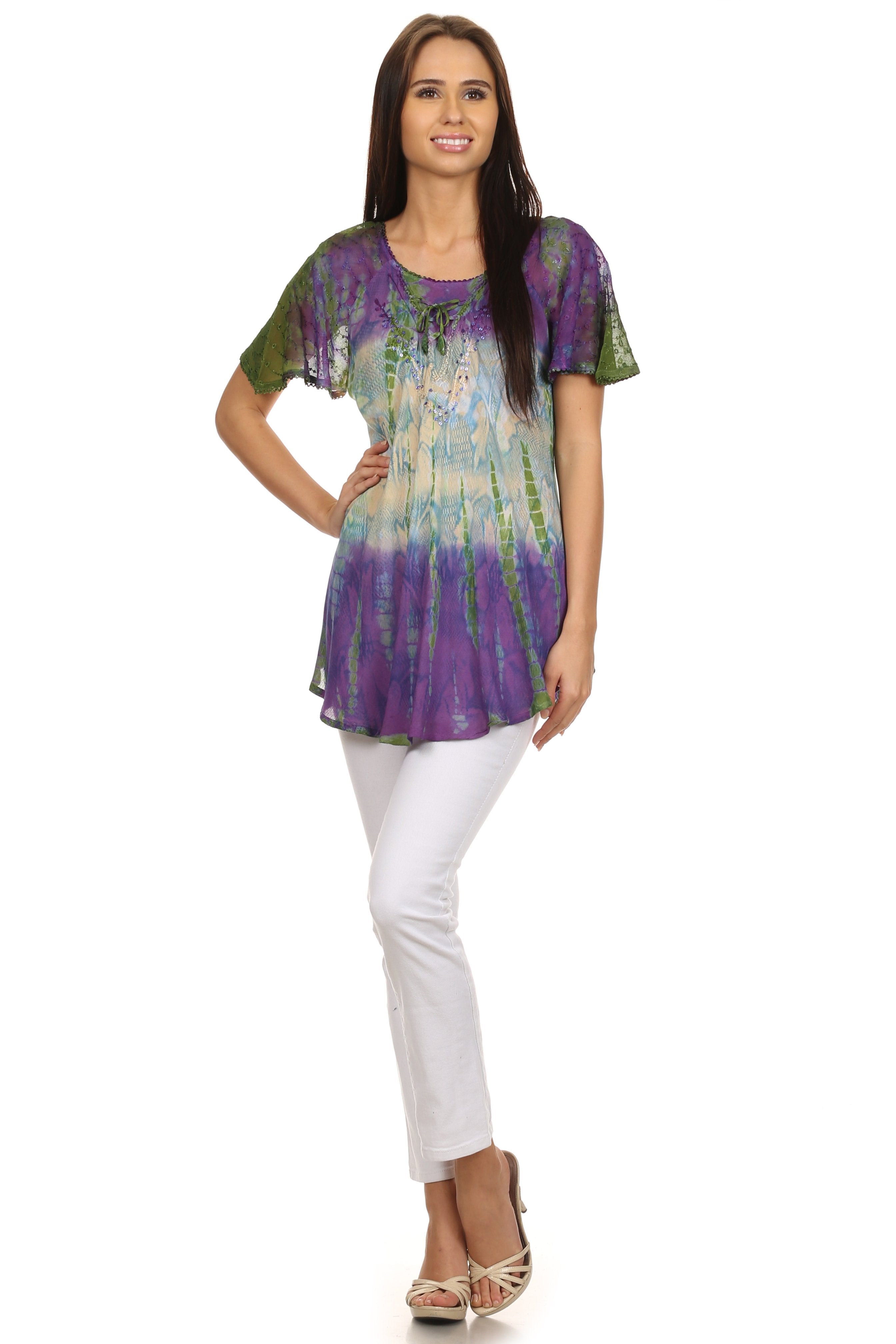 Woman wearing a colorful tunic and white pants on a white background