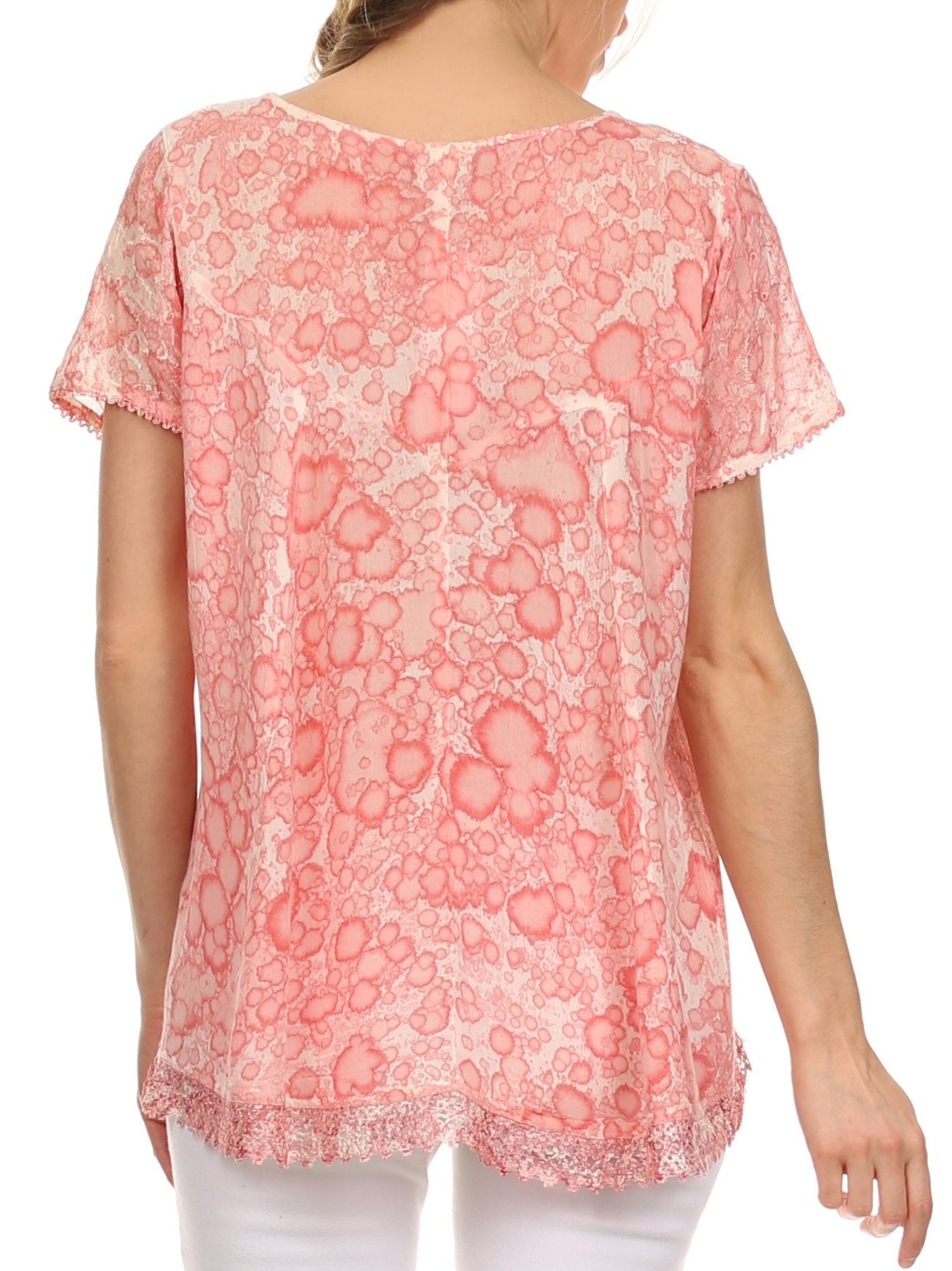 Pink floral patterned top worn by a person on a white background