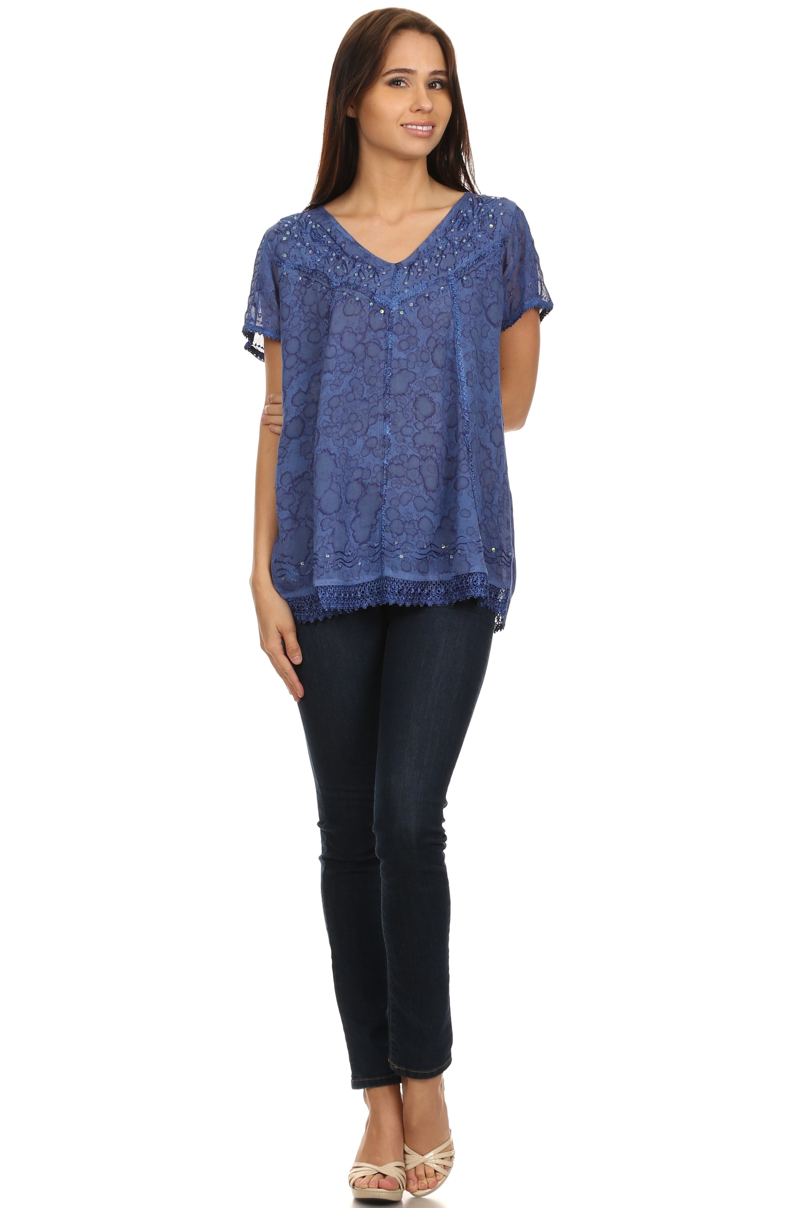 Woman wearing a blue patterned top and black pants on a white background