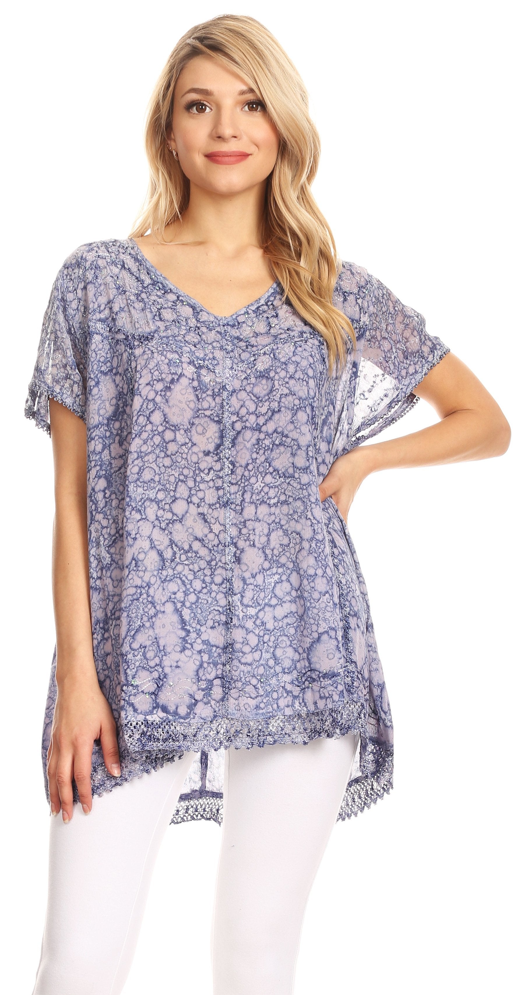 Woman wearing a blue floral patterned top with white pants on a white background