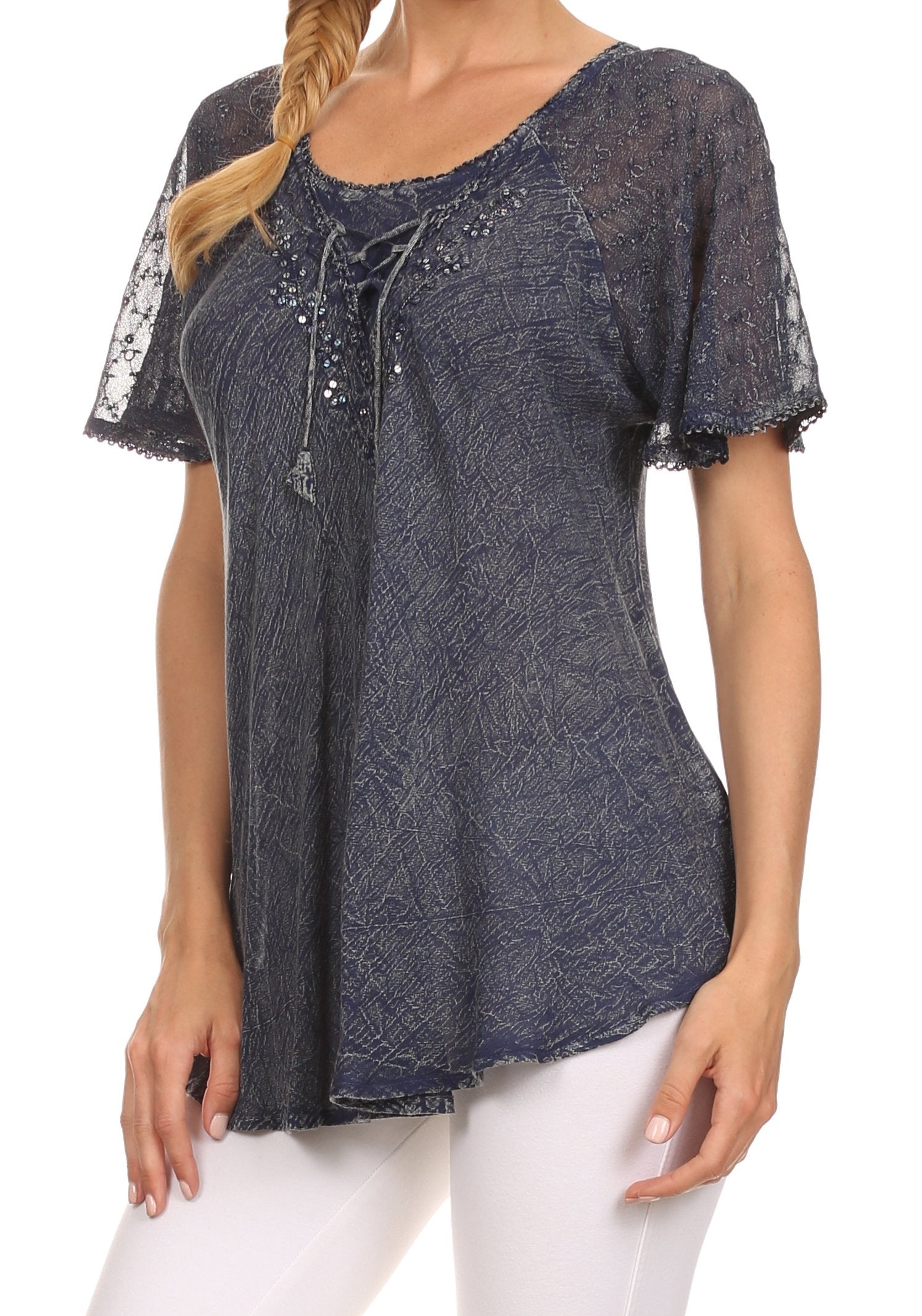 Woman wearing a dark blue patterned top with lace sleeves on a white background