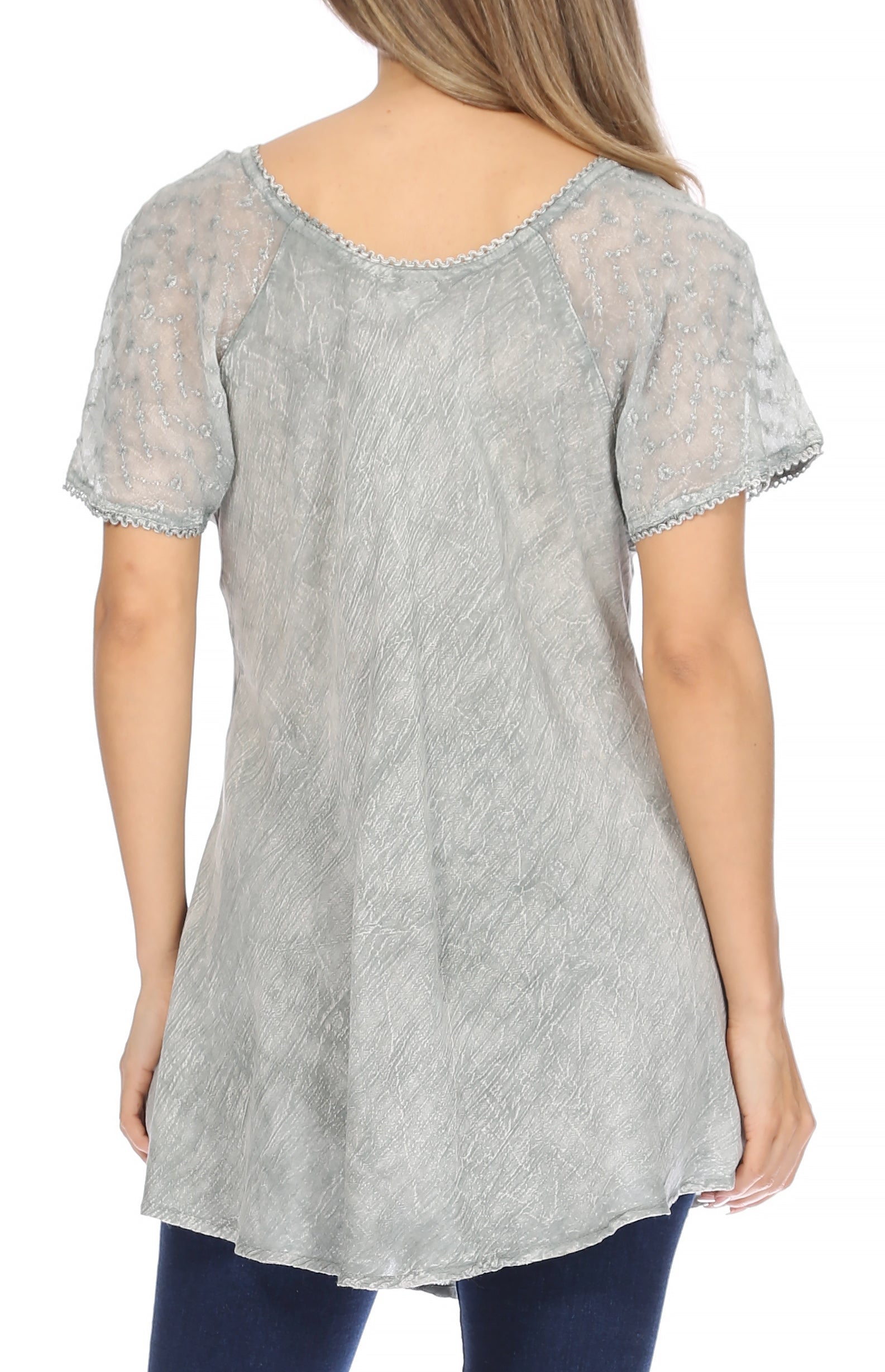 Woman wearing a light gray lace-trimmed top with a white background