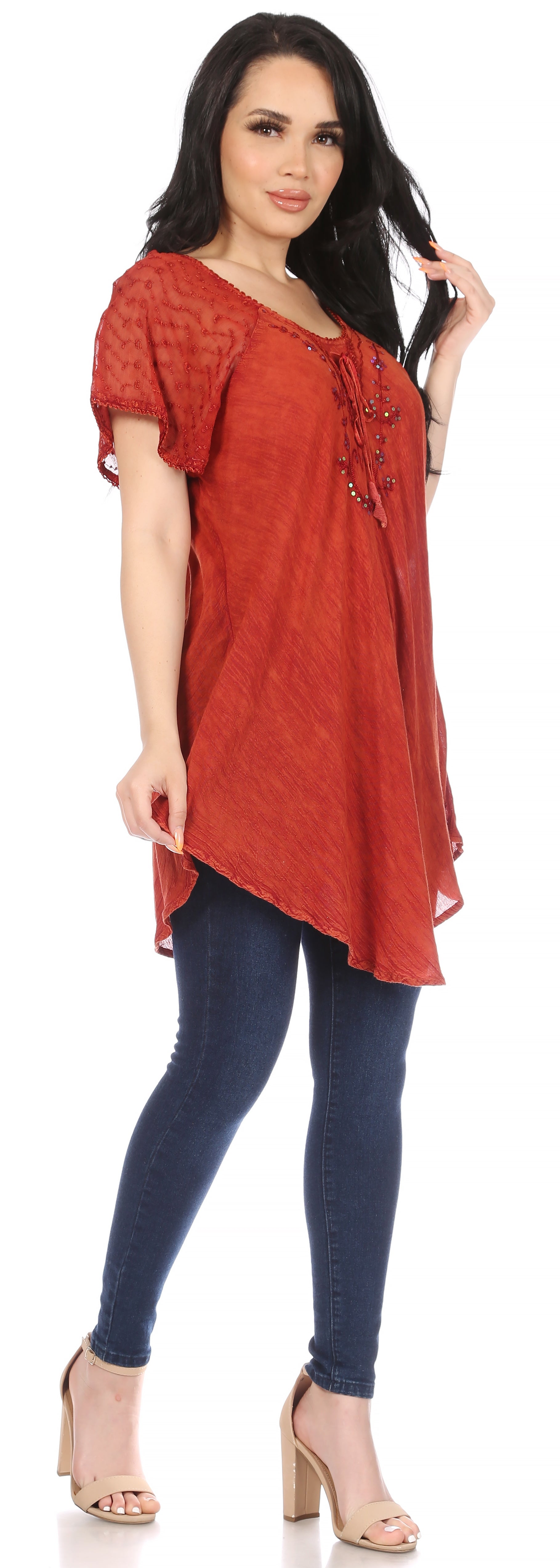 Woman wearing a red top and blue jeans on a white background
