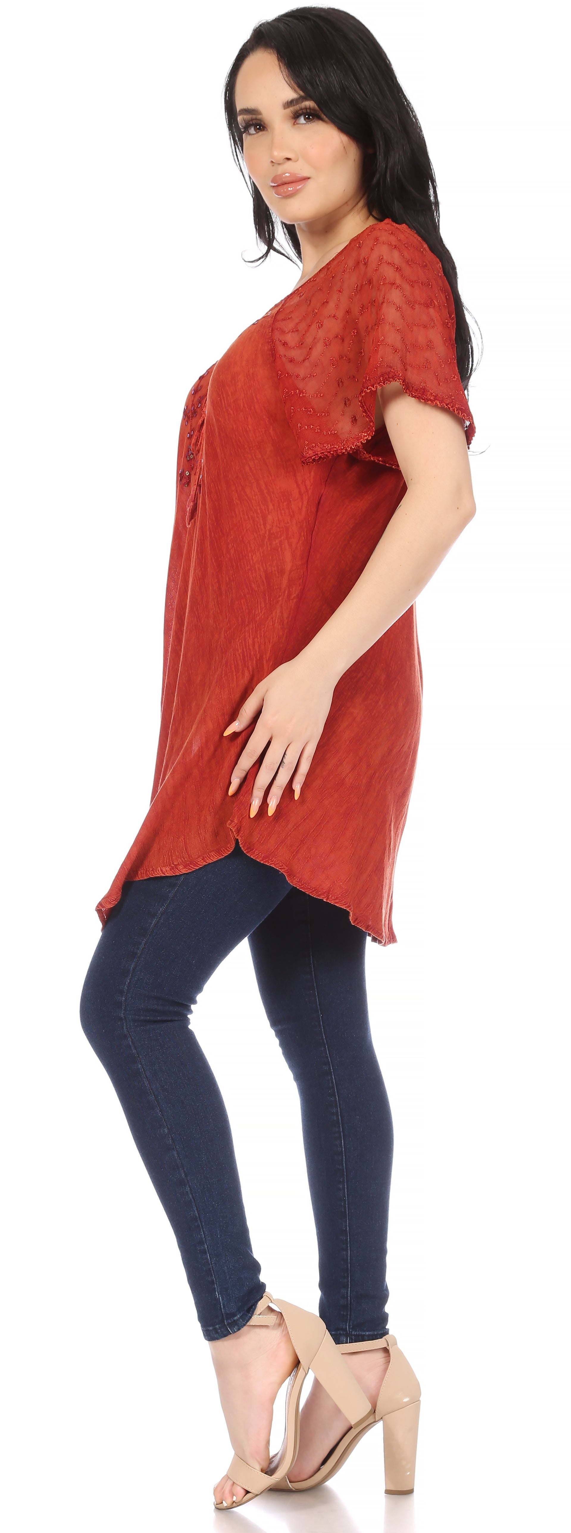 Woman wearing a red top and blue jeans on a white background