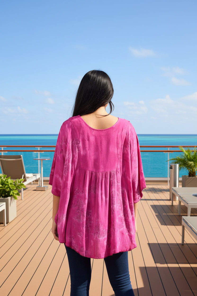 Pink tie-dye blouse worn by a person on a white background