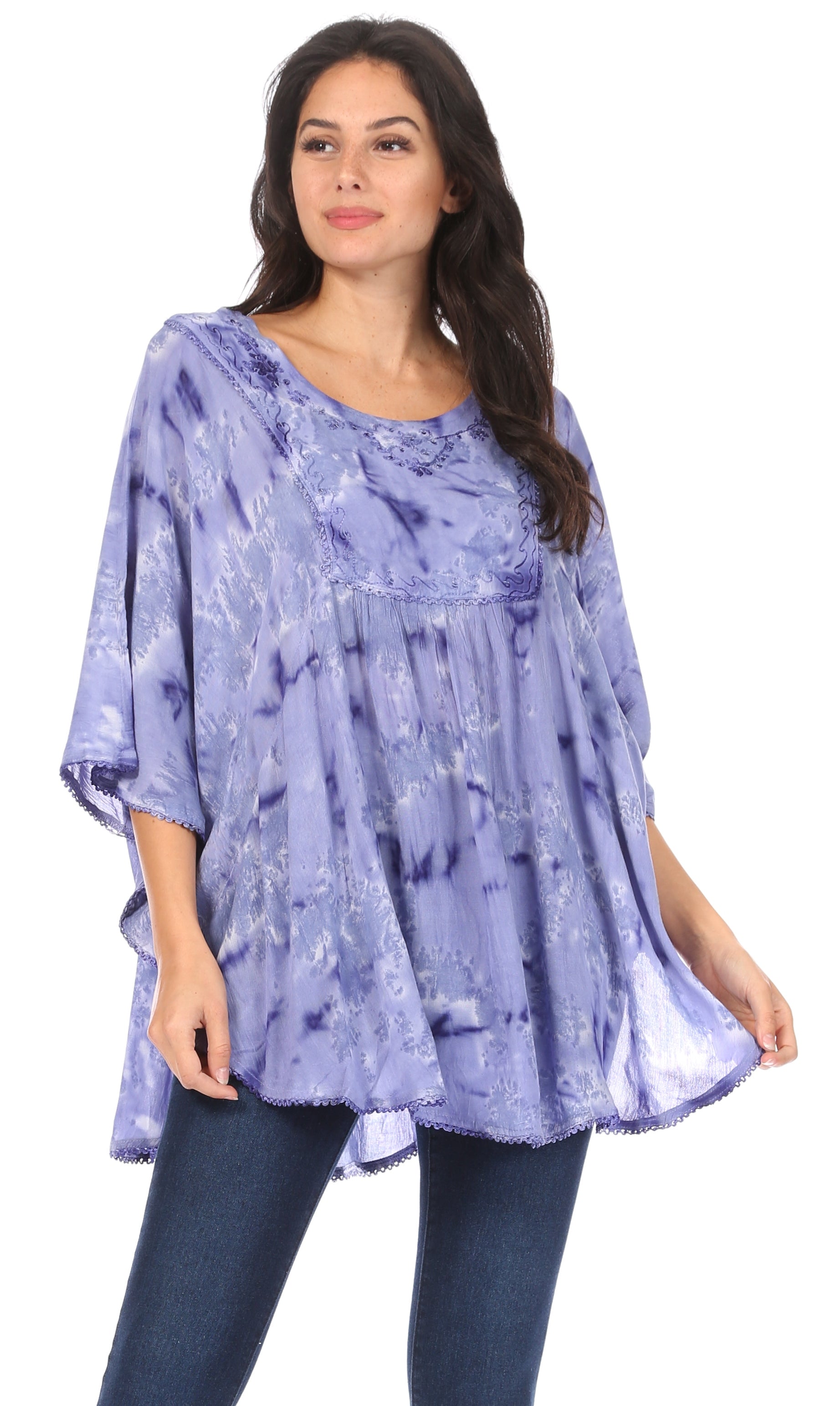 Woman wearing a purple patterned top and jeans on a white background