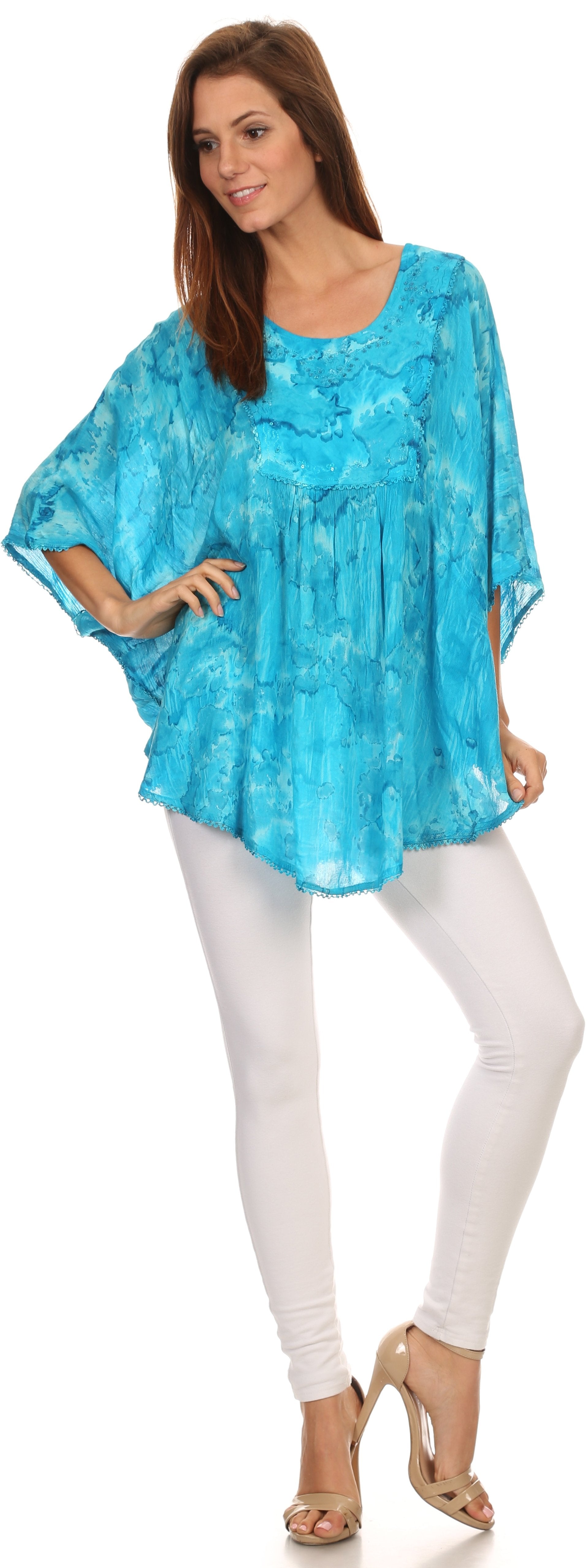 Woman wearing a blue tie-dye top and white pants on a white background