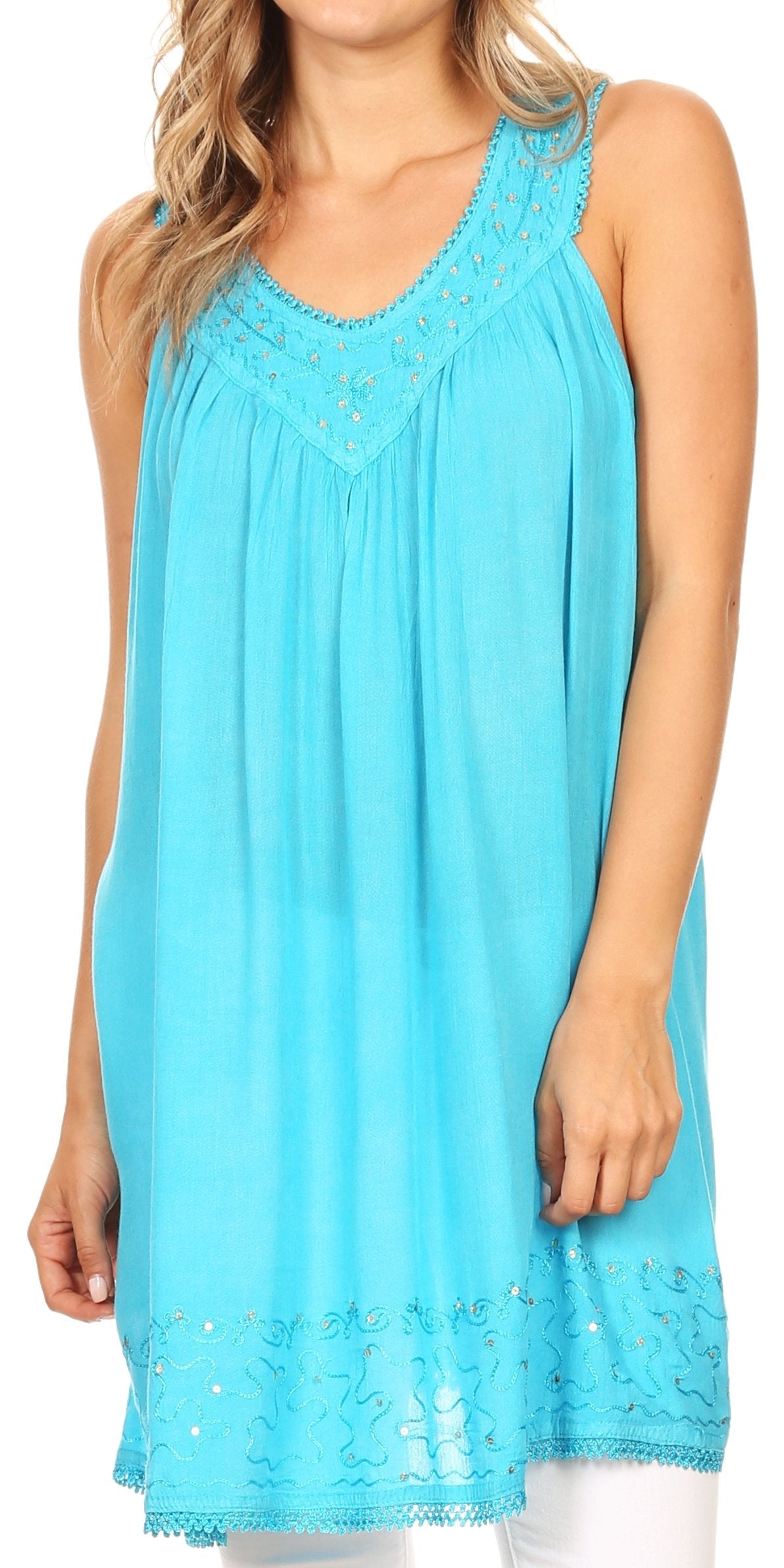 Woman wearing a turquoise sleeveless dress with lace details on a white background