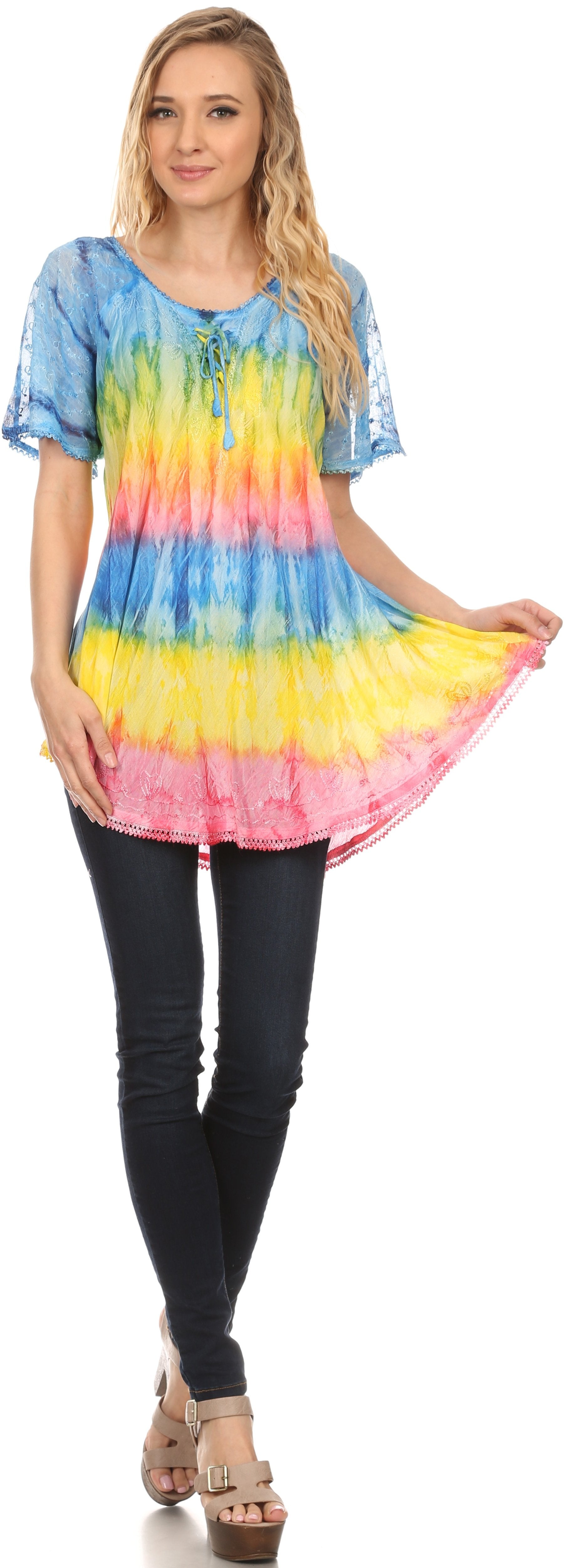 Woman wearing a colorful tie-dye shirt and black pants on a white background