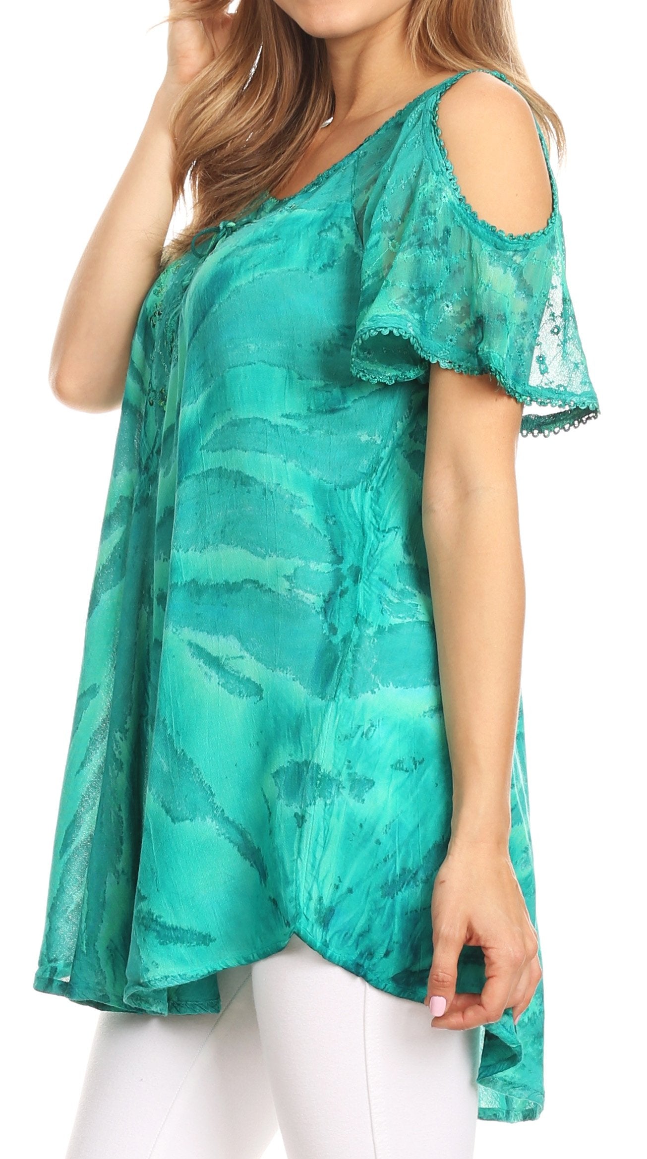 Woman wearing a green patterned top with cold shoulder design on a white background