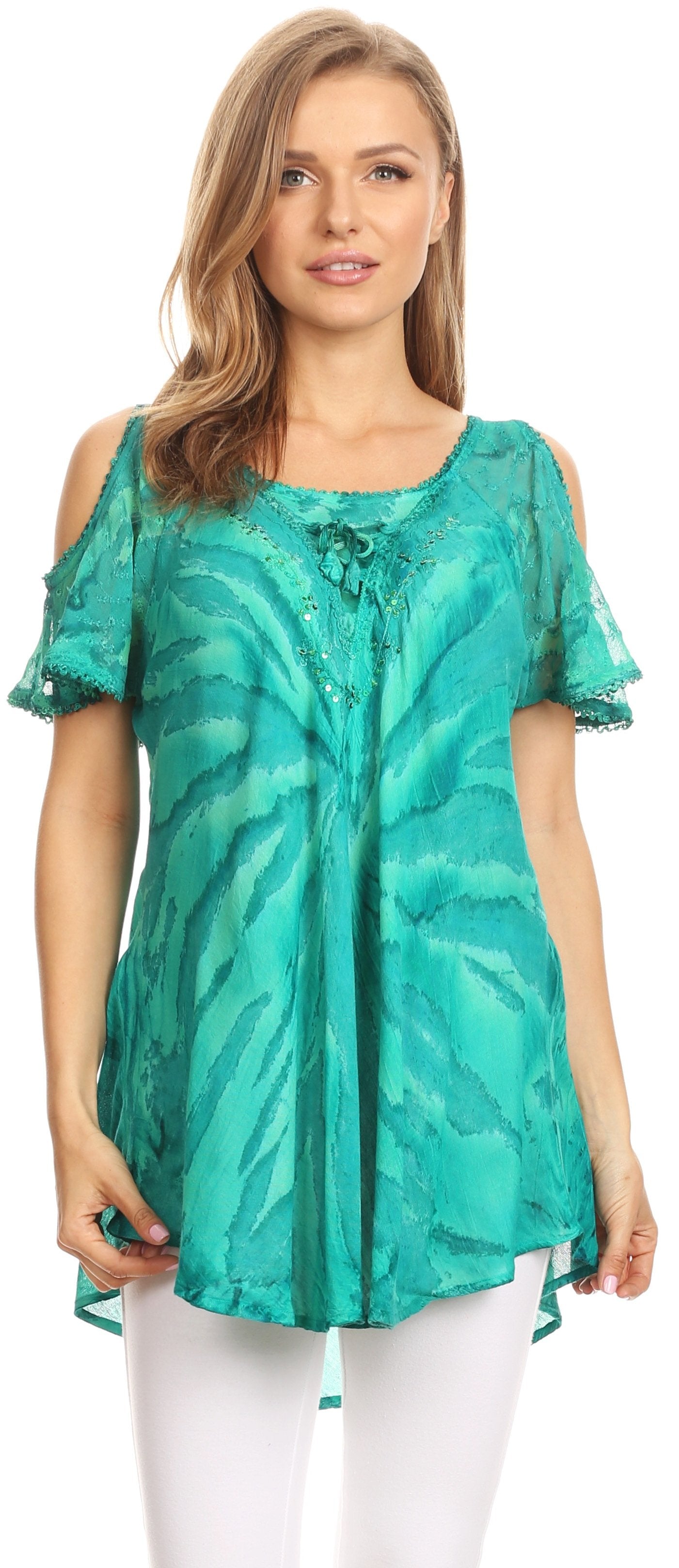 Woman wearing a green patterned top with white pants