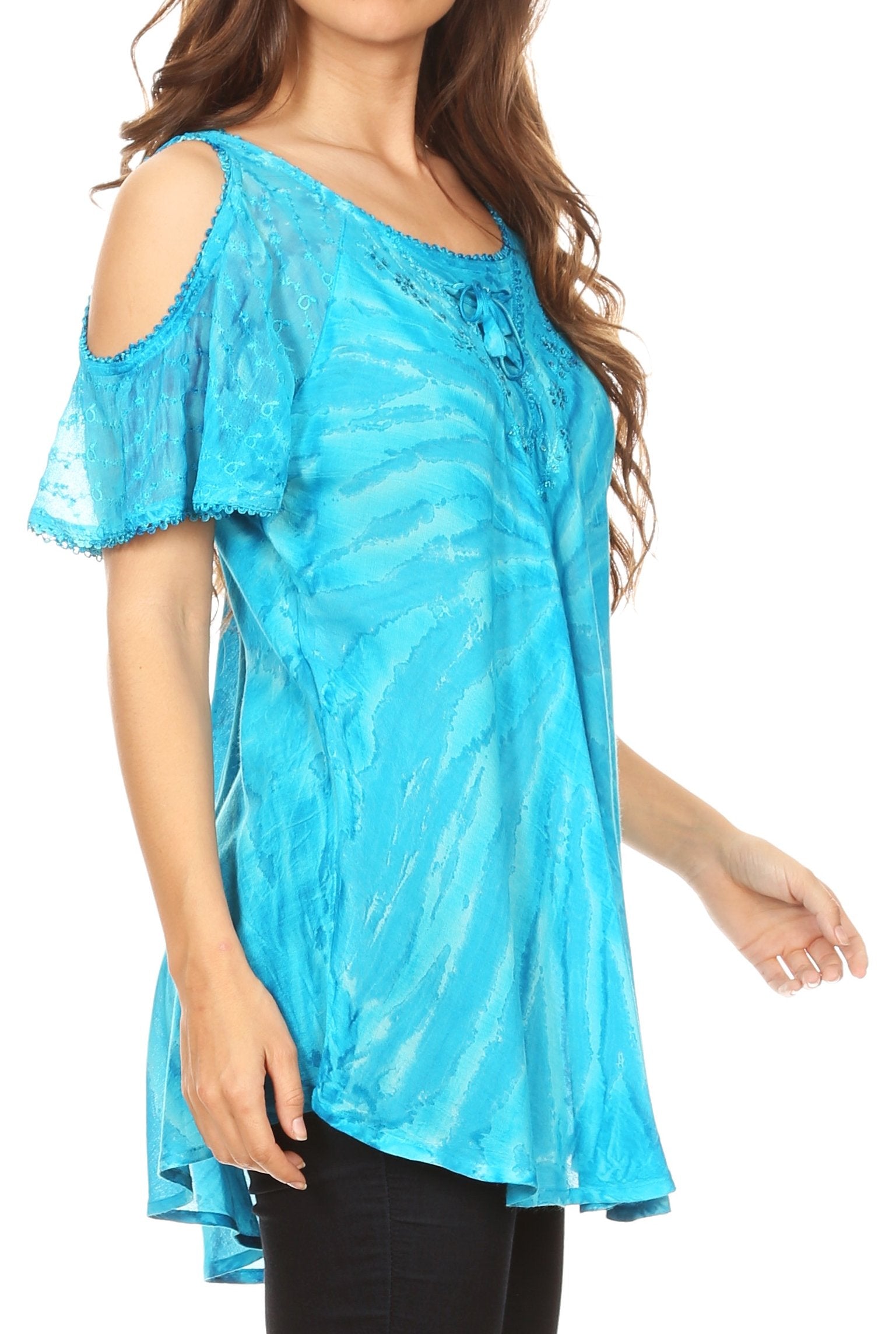 Woman wearing a blue tie-dye top with cut-out shoulders on a white background
